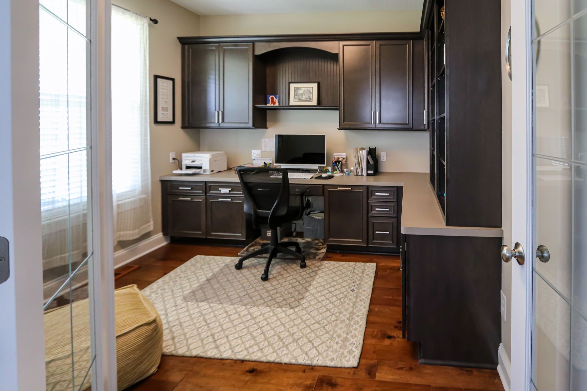 A home office with a desk , chair , computer and printer.