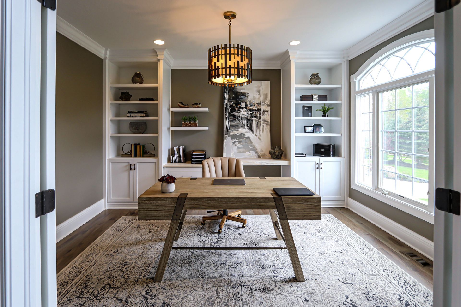 A home office with a wooden desk and a rug.