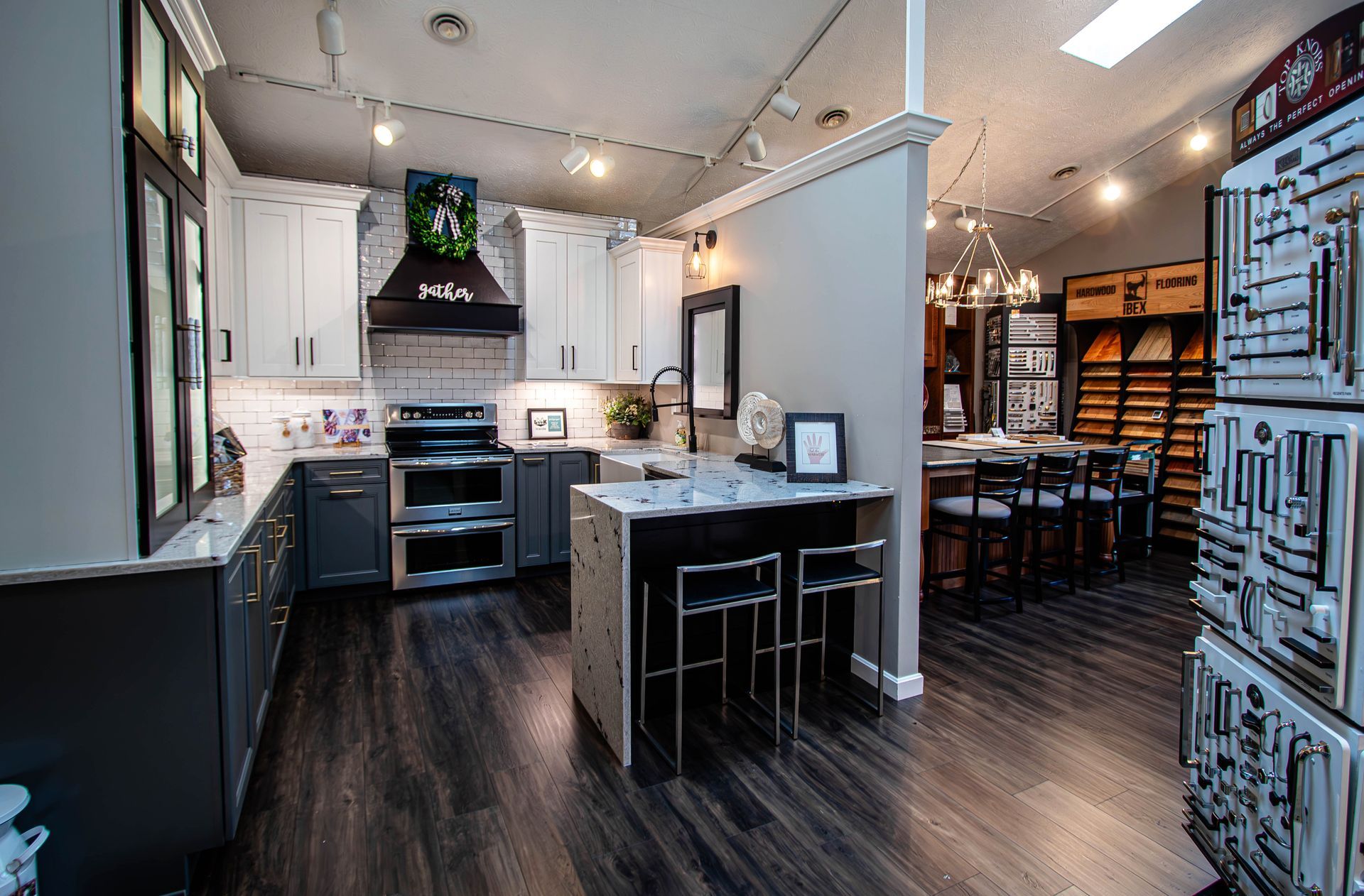 A kitchen with white cabinets and stainless steel appliances in a showroom.