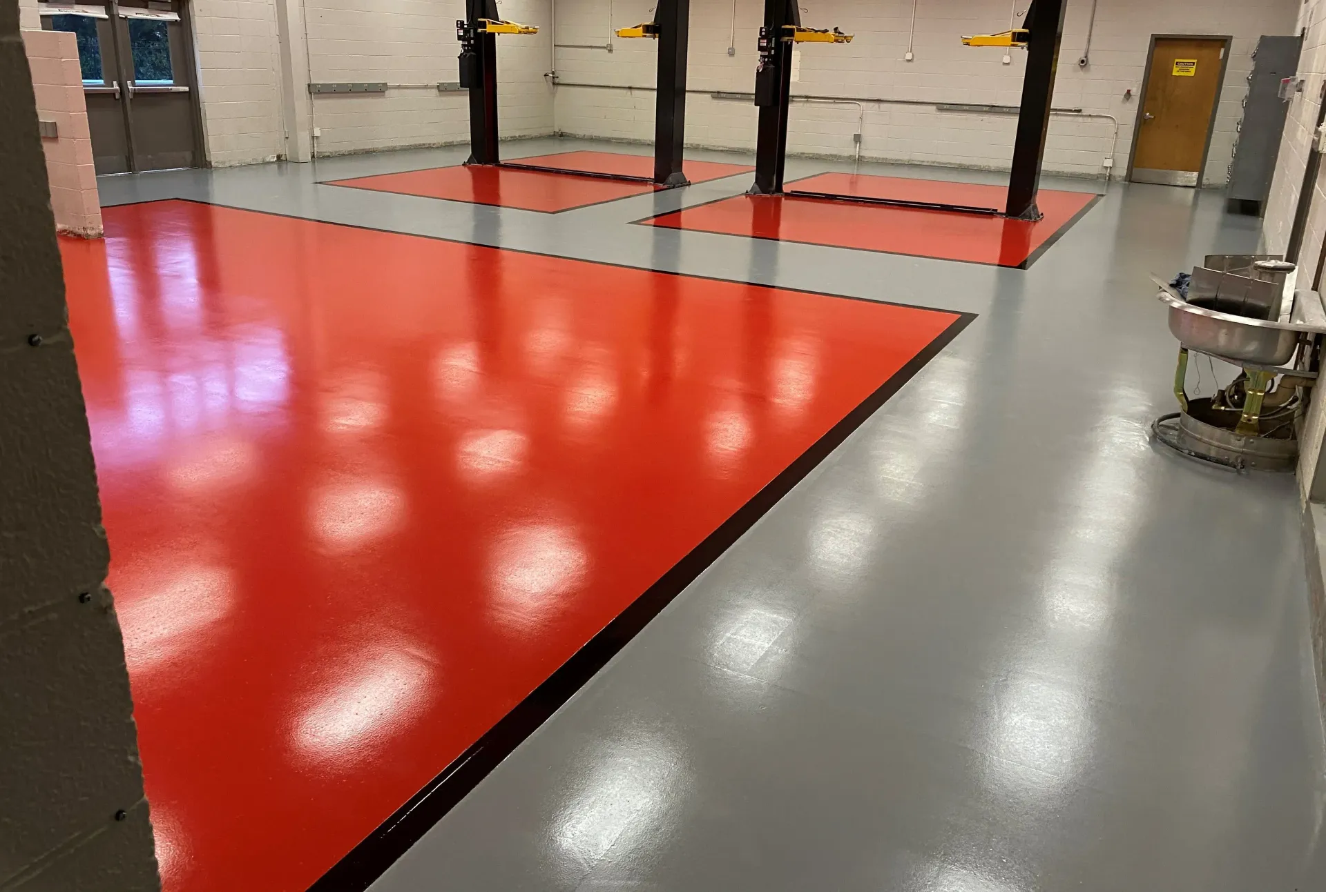A garage with a red floor and a gray floor.