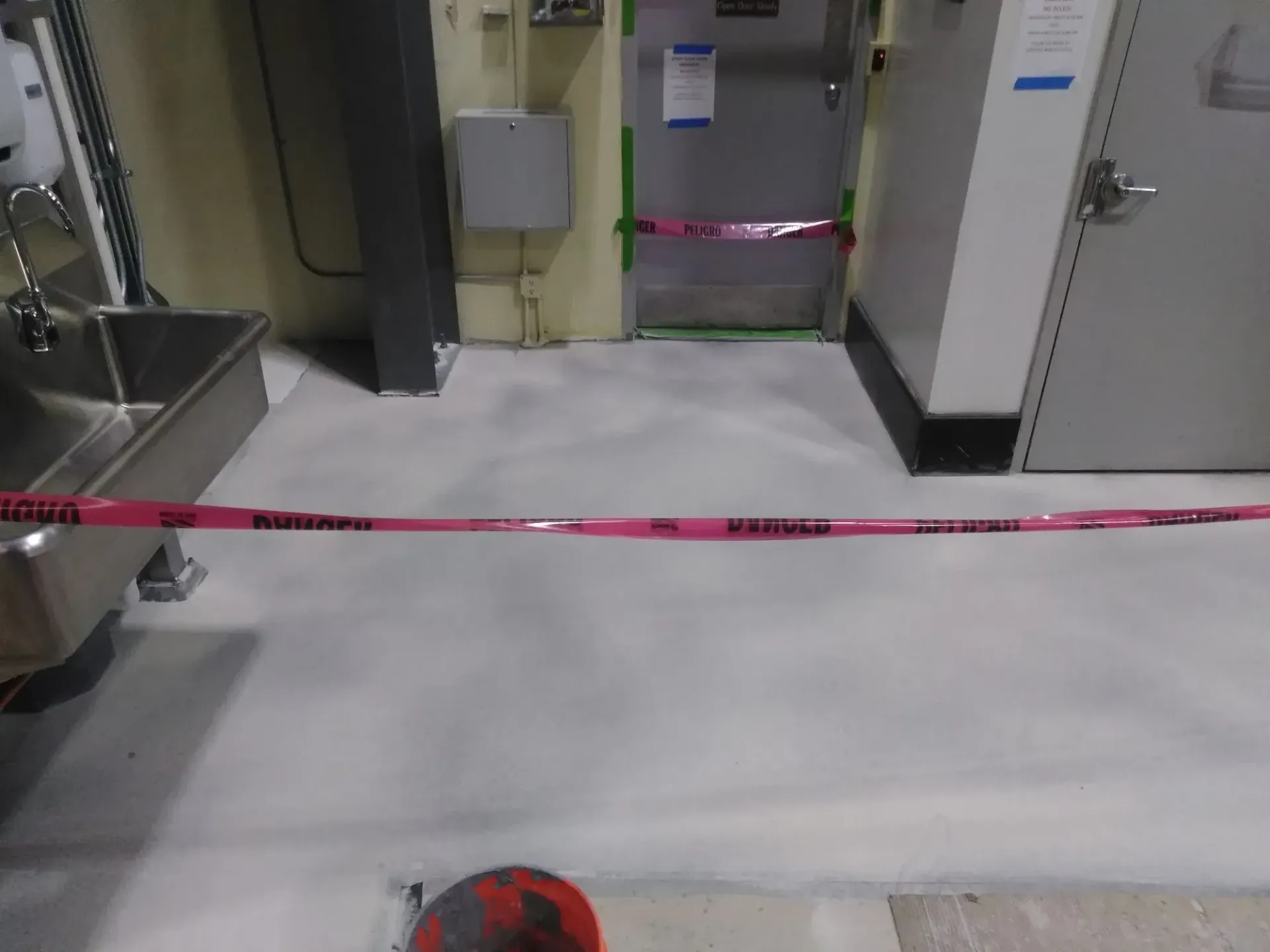 A room with a sink and a pink tape on the floor