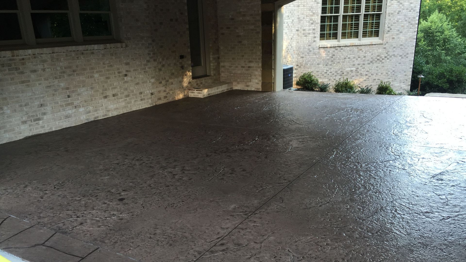 A brick building with a decorative concrete driveway in front of it.
