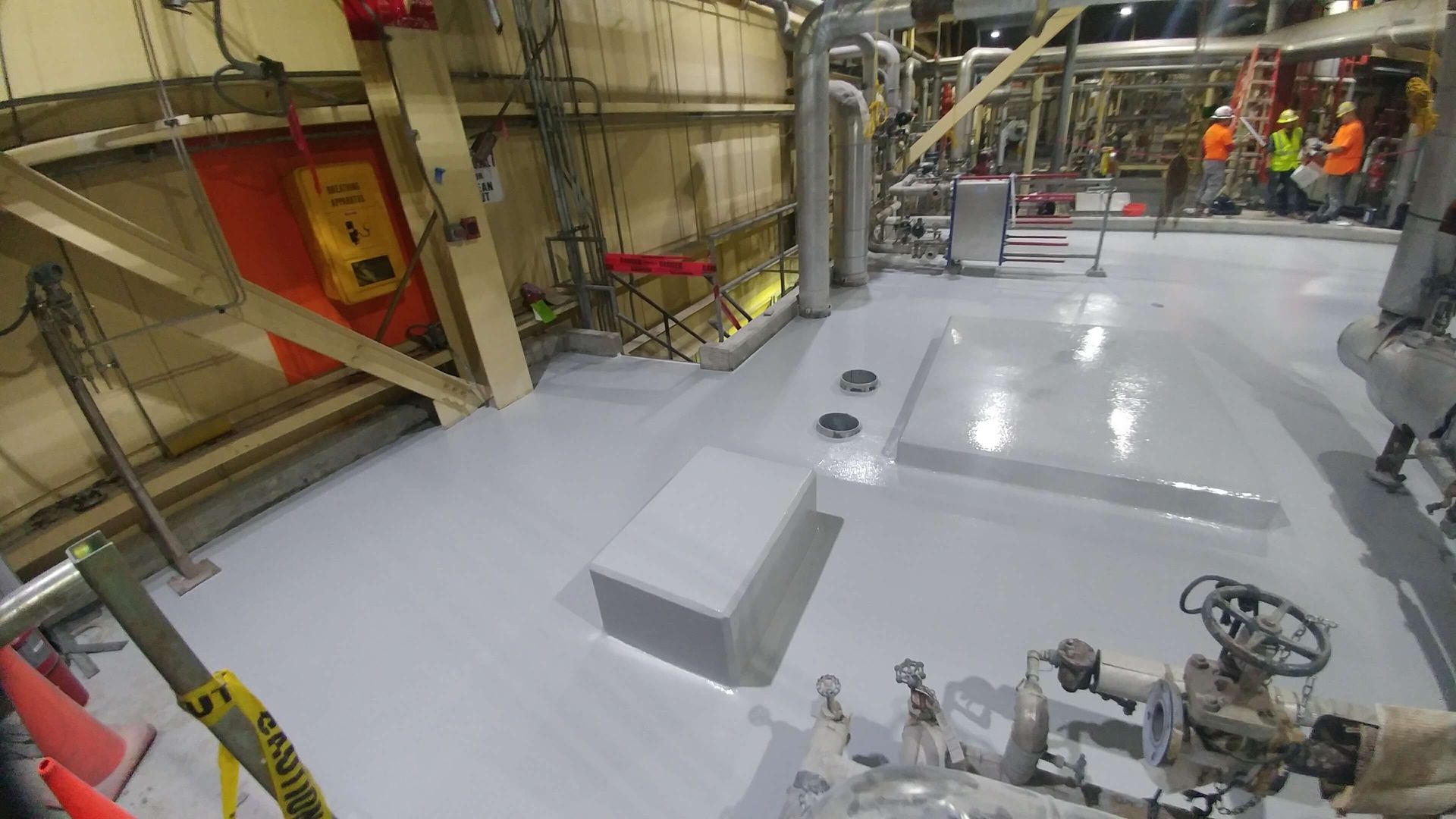 A large room with a lot of pipes and valves on the floor.