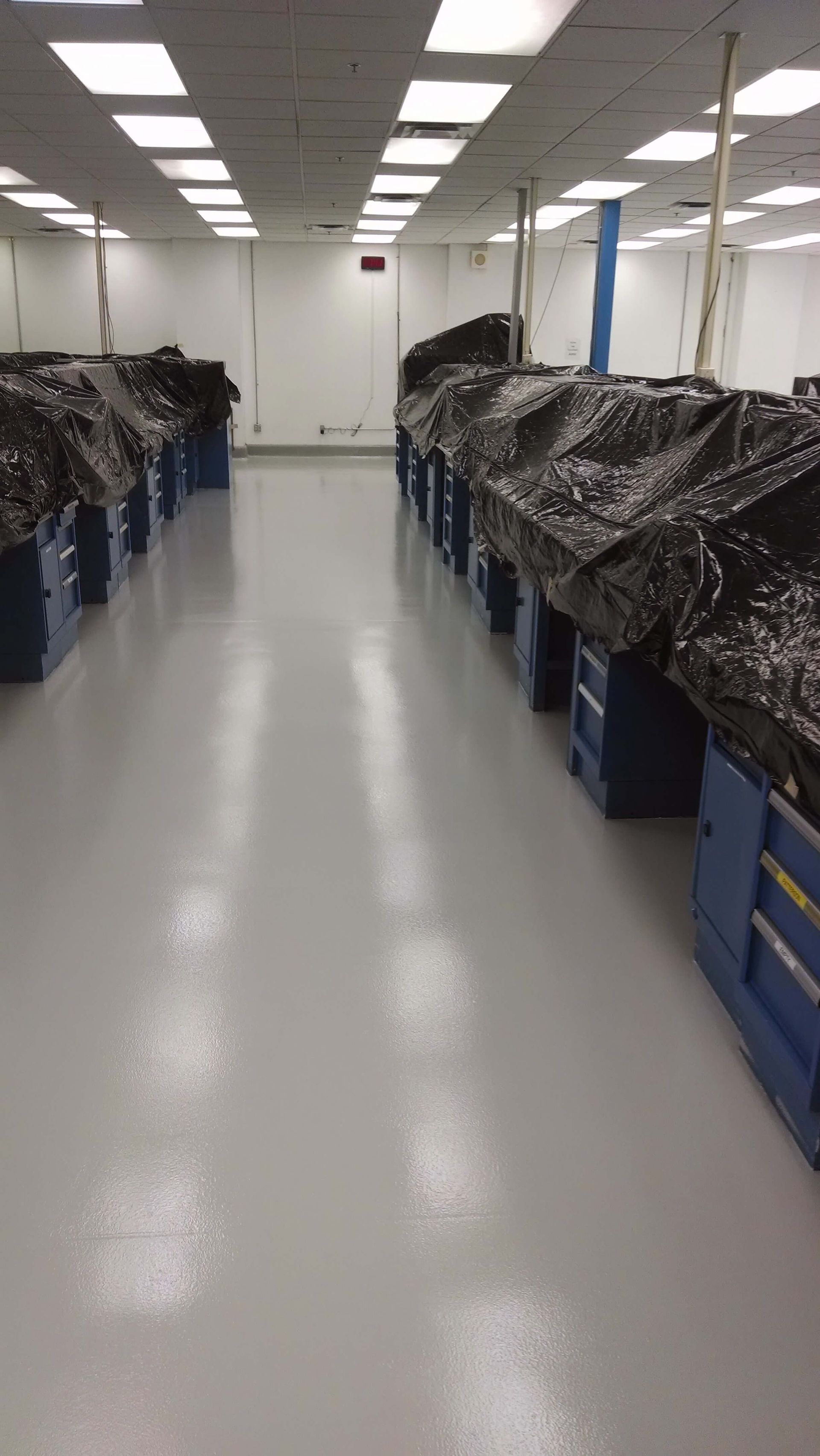A large room with a lot of boxes on the polished concrete floor.