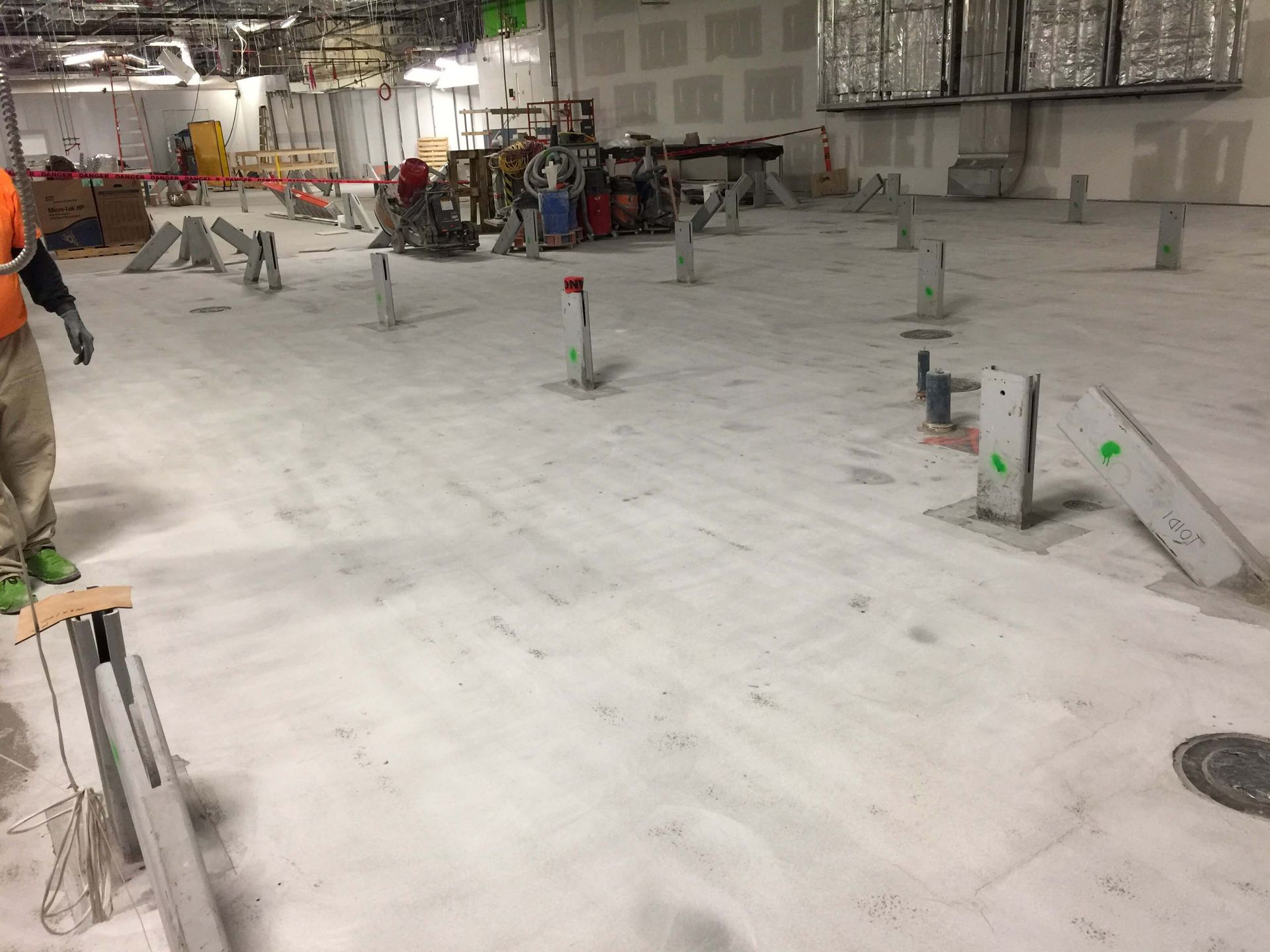 A man is standing in a large room with a concrete floor.