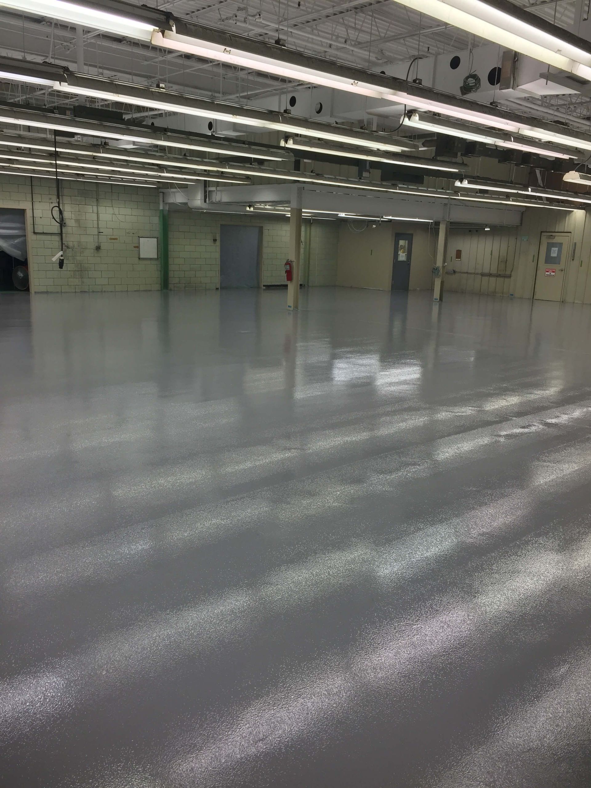 A large empty warehouse with a concrete floor and ceiling.