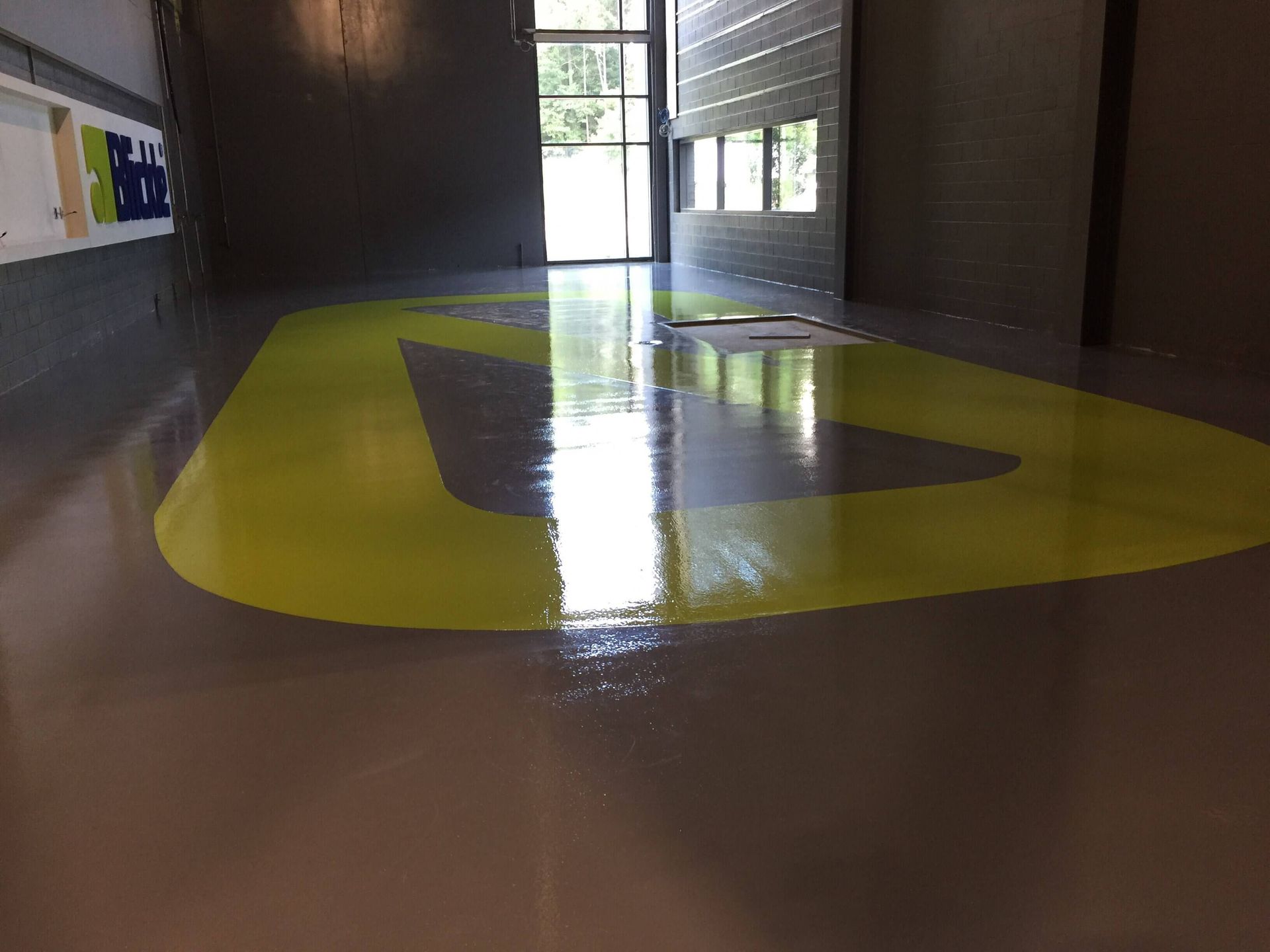 A large empty room with a yellow triangle on the floor.
