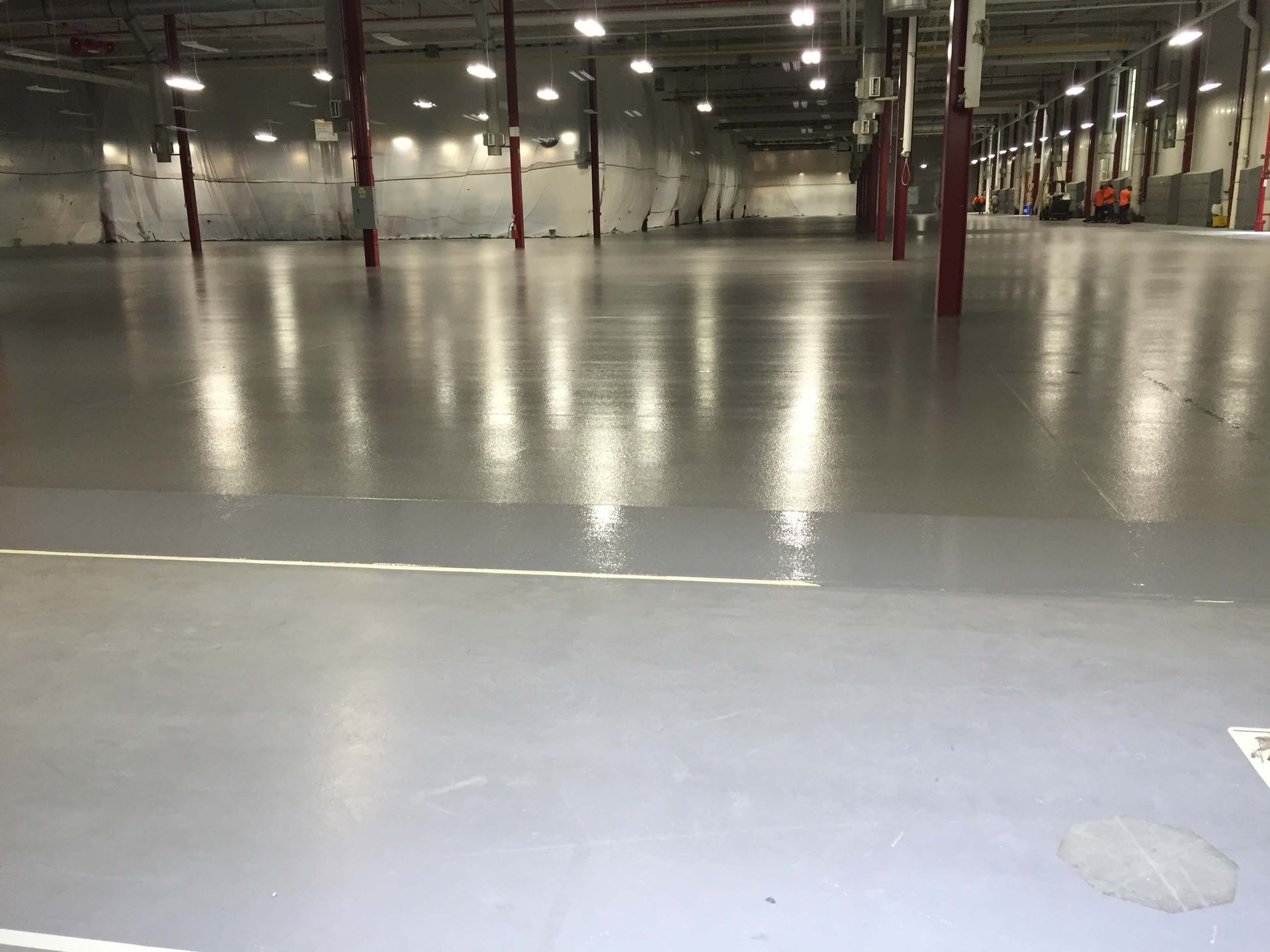 A large empty warehouse with a shiny concrete floor.