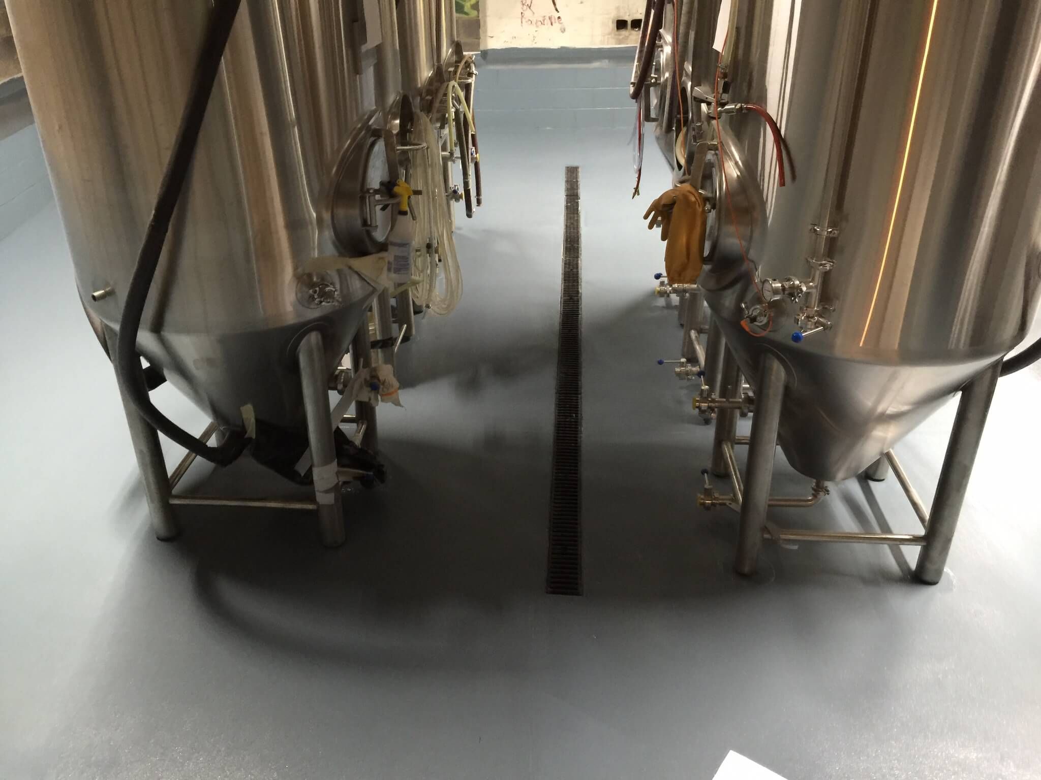 A row of stainless steel tanks in a factory