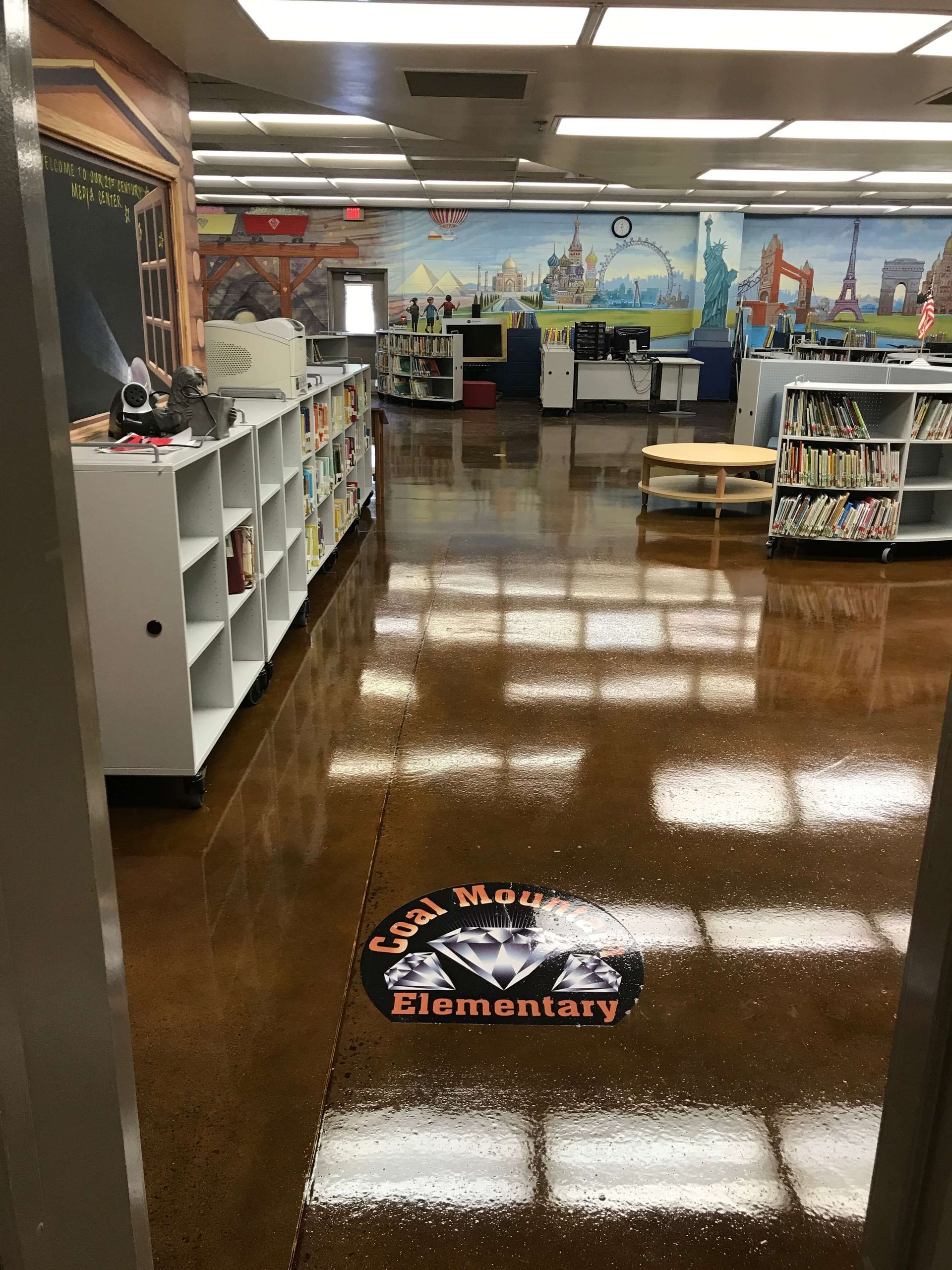 A library with a painting on the wall and a shiny floor.