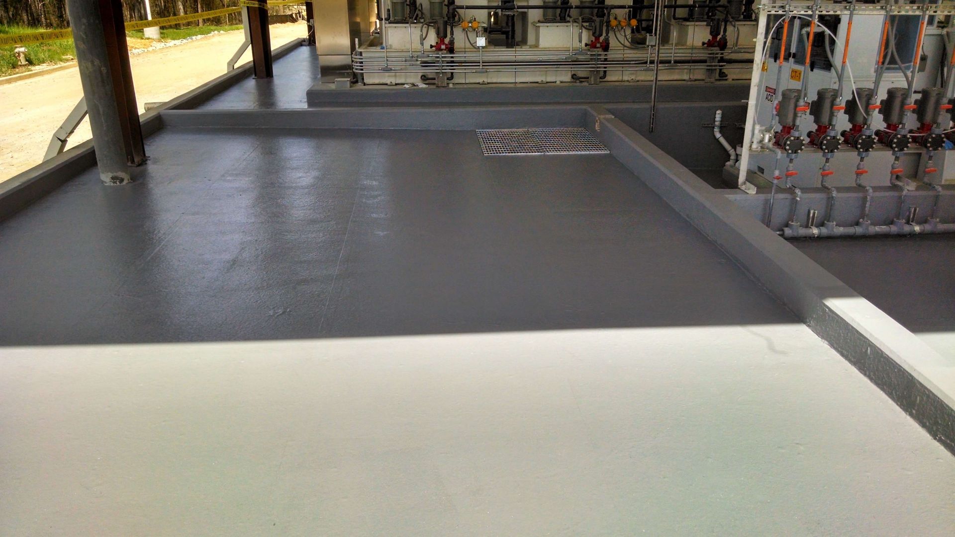 A gray and white floor with a drain in the middle of it.