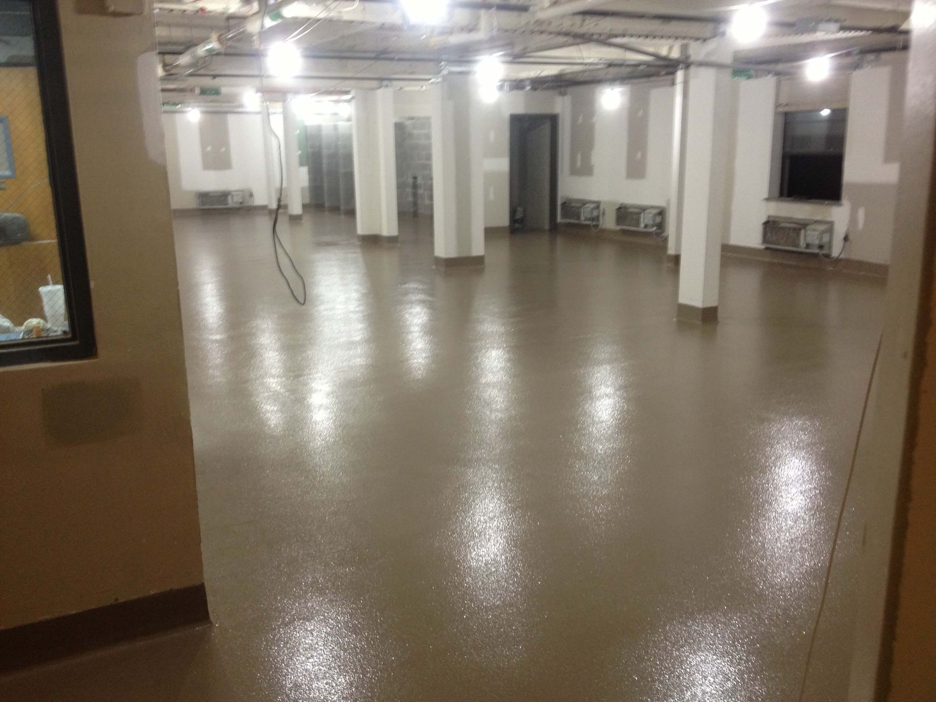 A large room with a brown floor and white walls.
