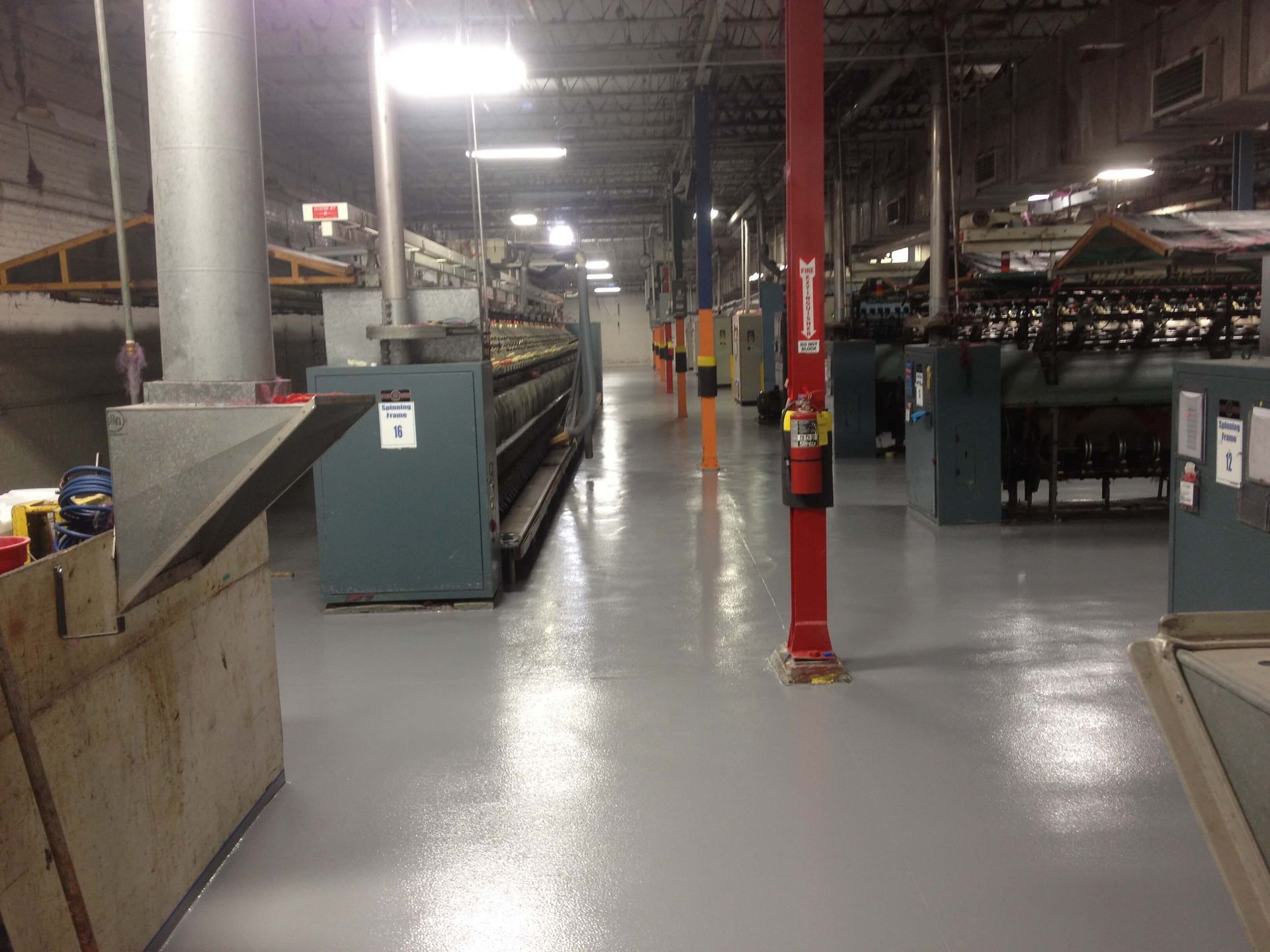 A large warehouse filled with lots of machinery and a fire extinguisher.