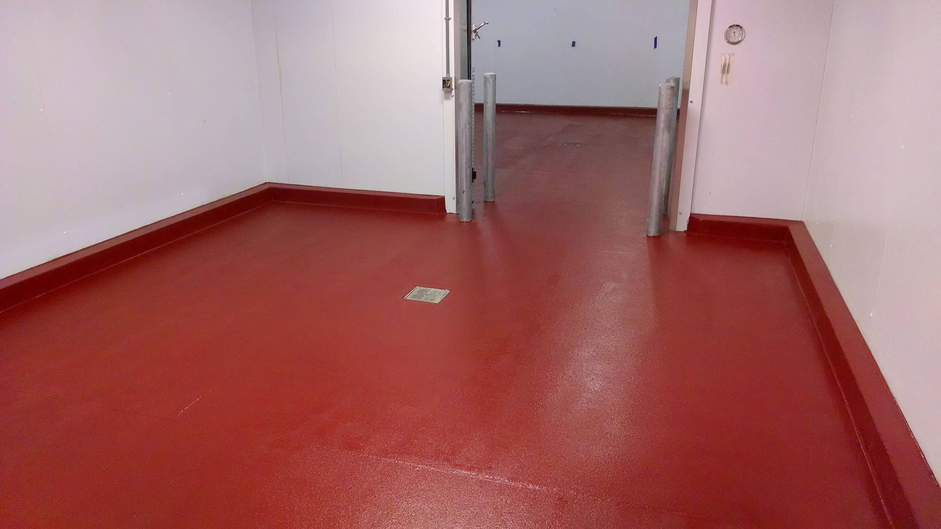 A room with a red floor and white walls.