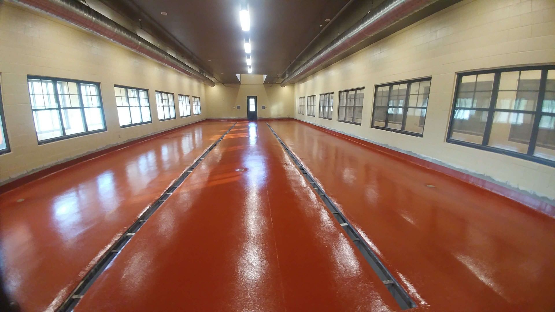 A large room with a red floor and a lot of windows