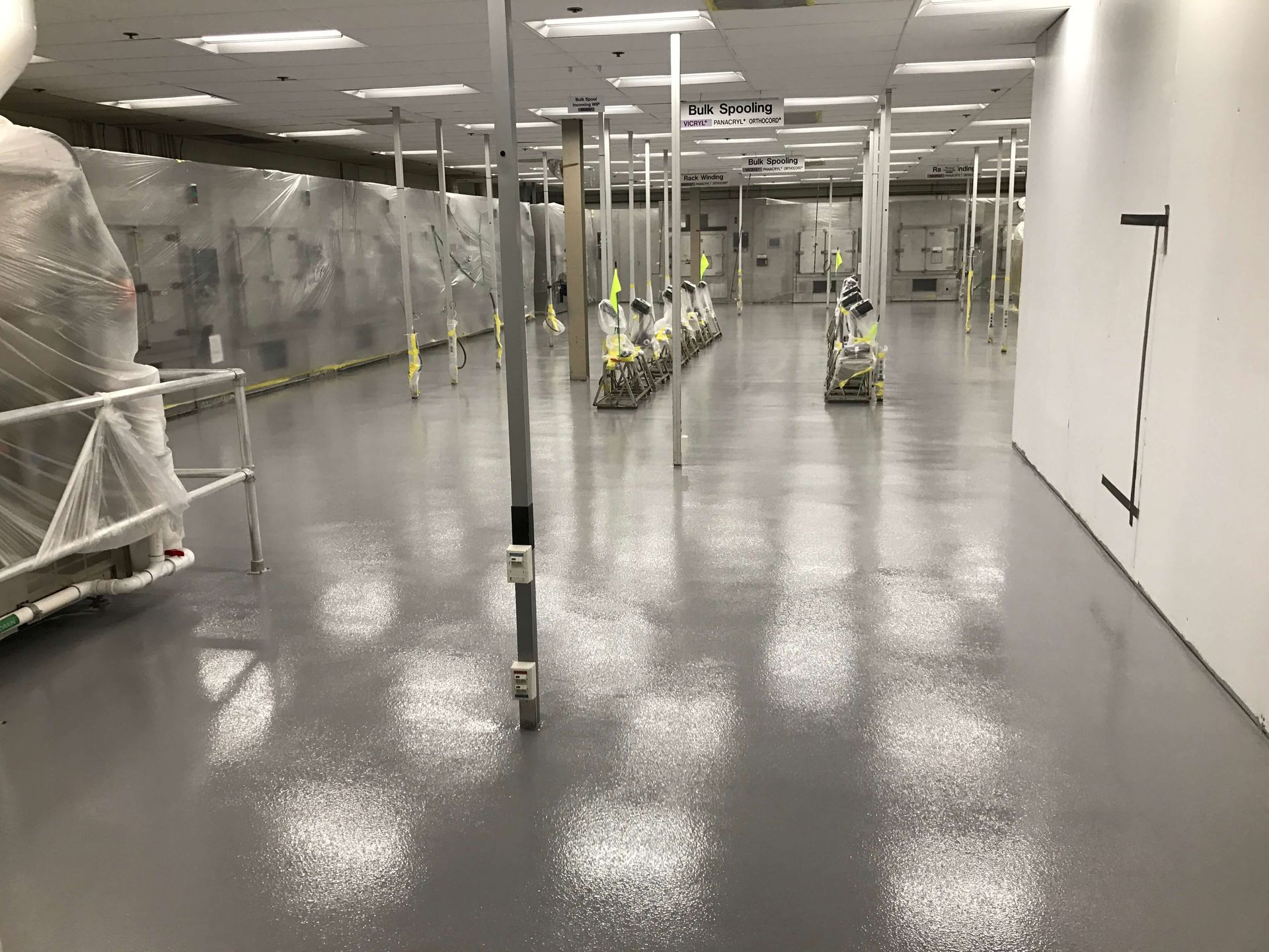 An empty warehouse with a gray floor and white walls