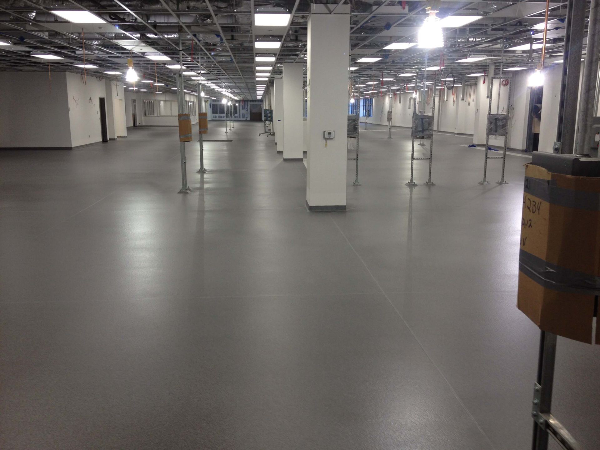 A large empty room with a gray floor and white walls.