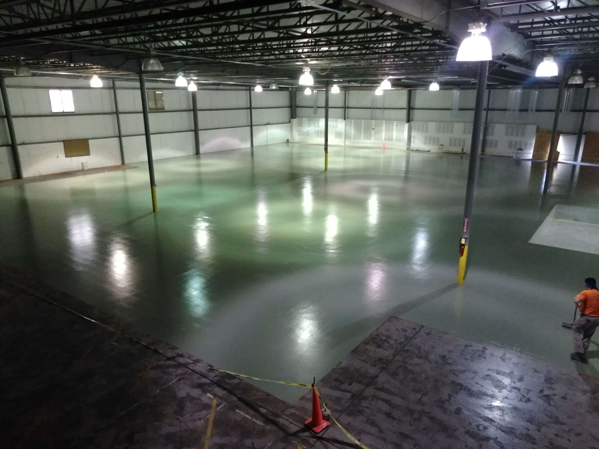 A man is standing in the middle of a large warehouse.