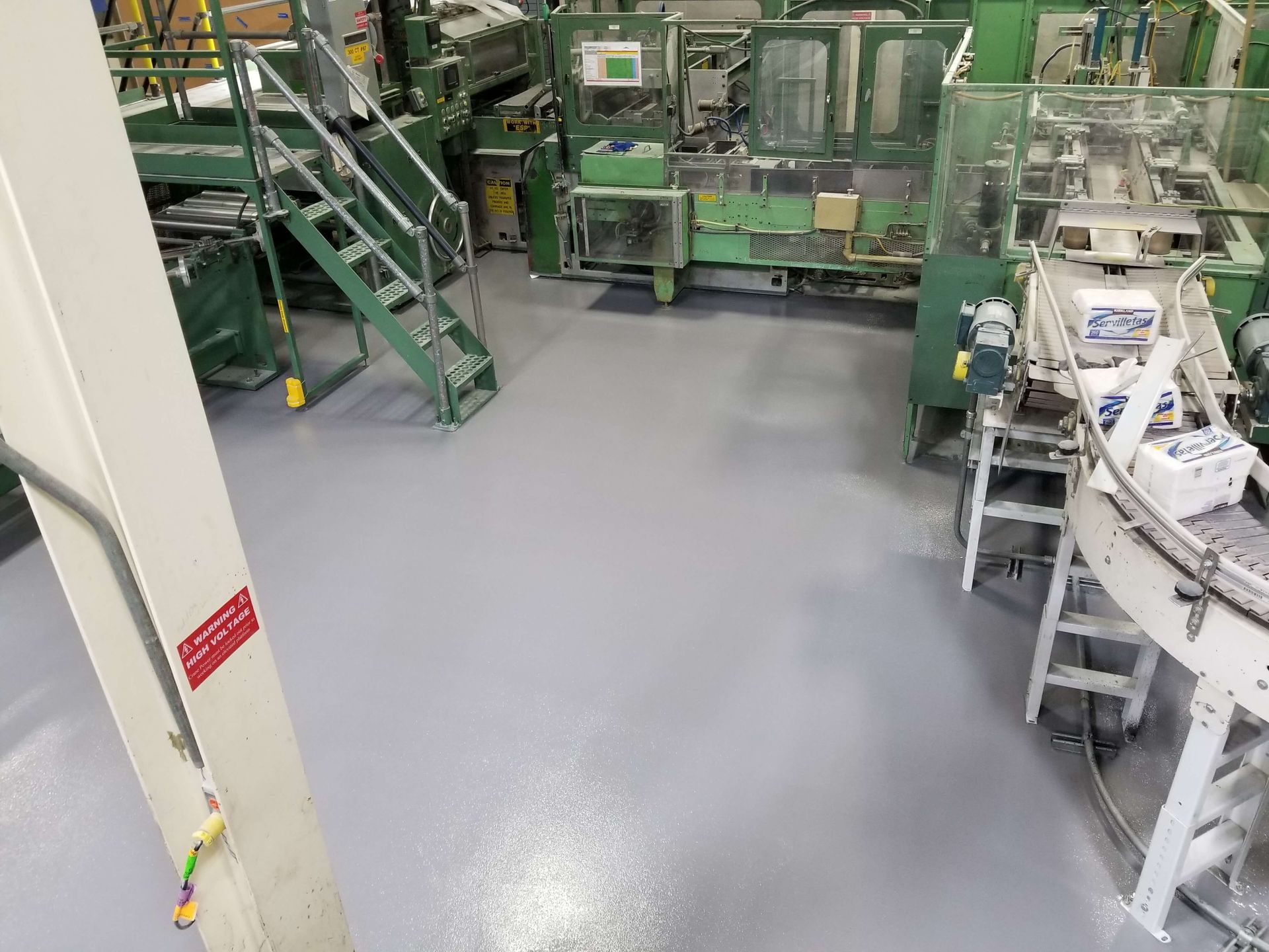 A factory with a lot of machinery and a gray floor.