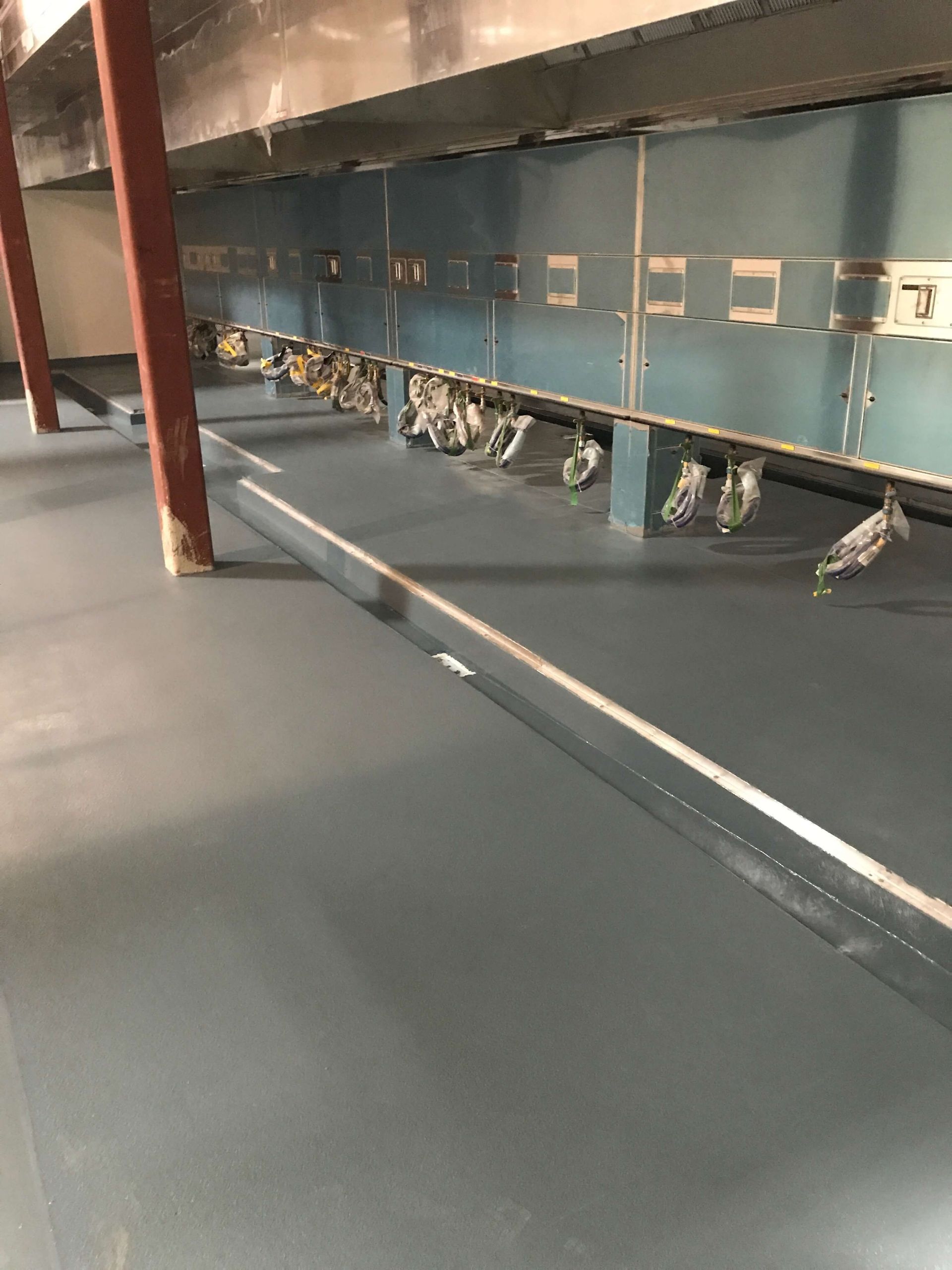 A row of bikes are lined up on a conveyor belt in a warehouse.