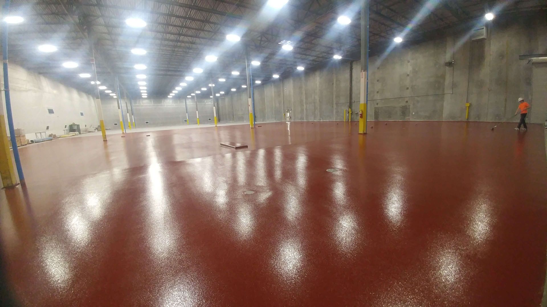 A large warehouse with a red floor and lots of lights.
