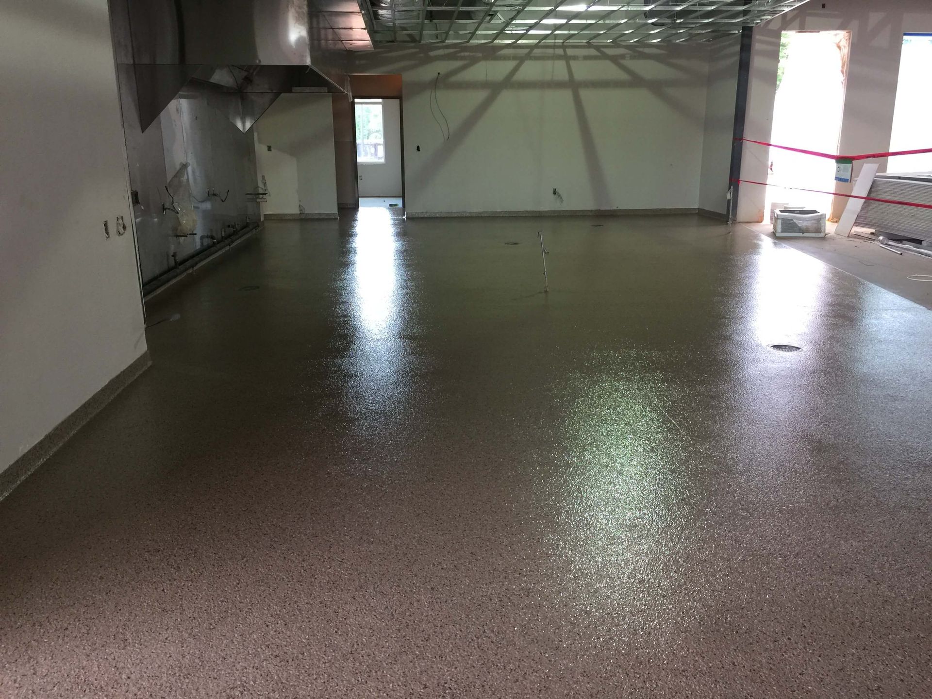 A large room with a shiny floor and a white wall.