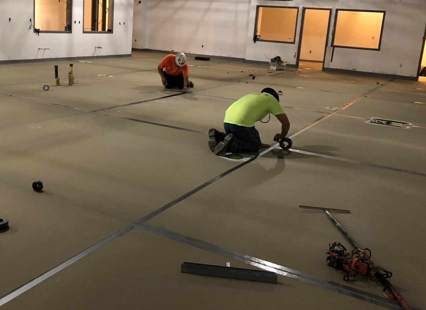 Two men are working on the floor of a building