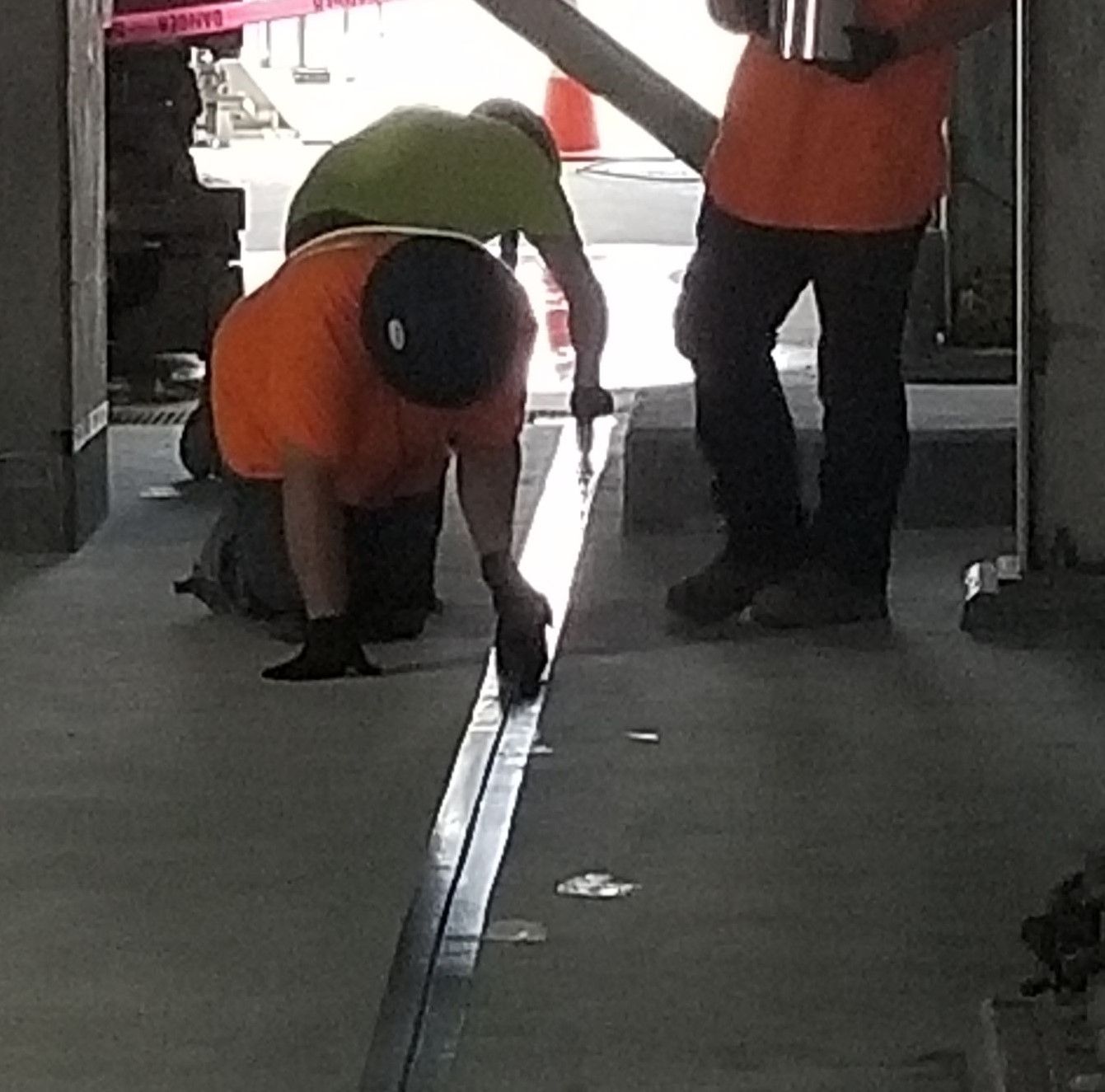 A group of construction workers are working on a concrete floor