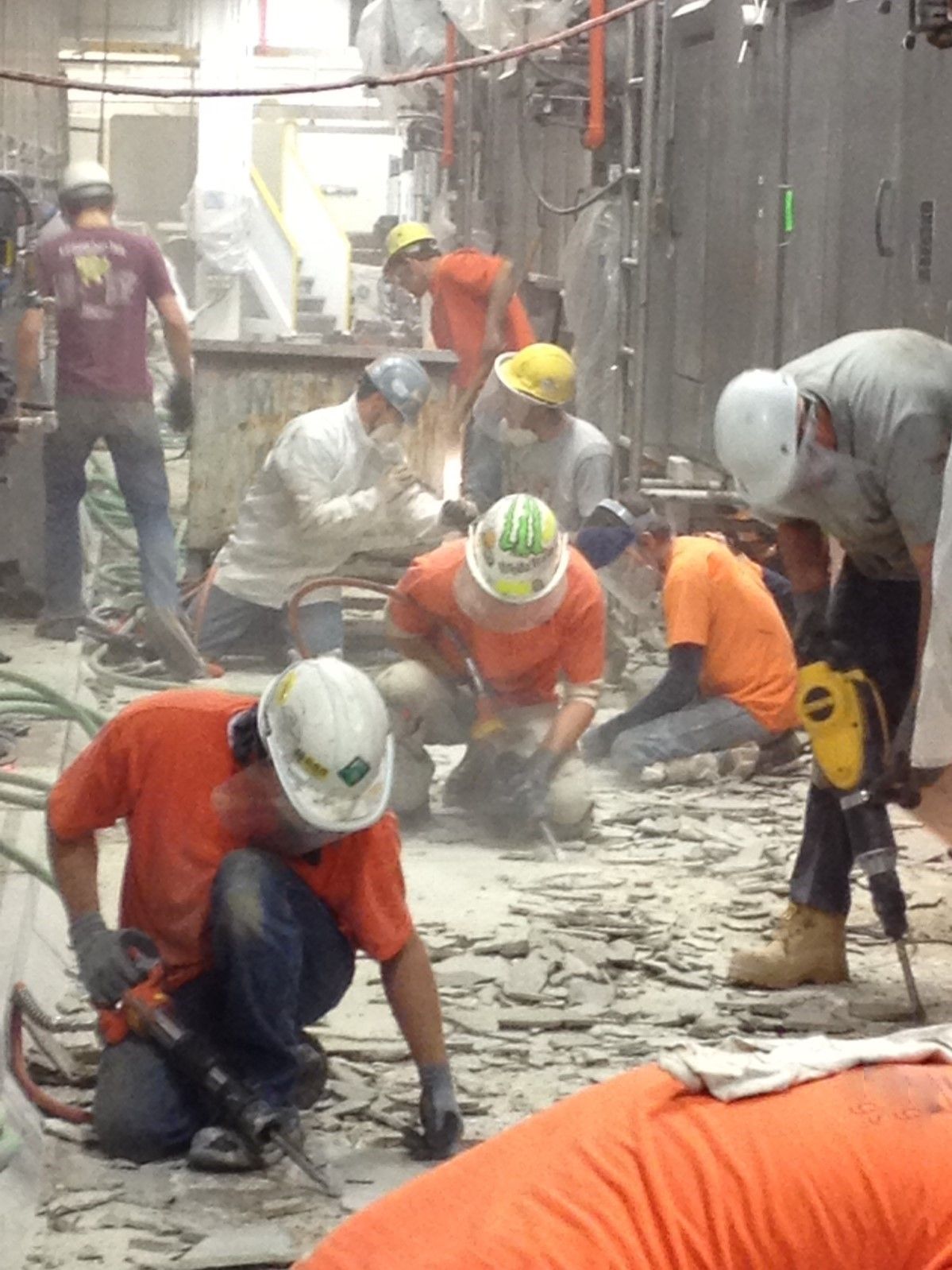 A group of construction workers are working on a concrete floor