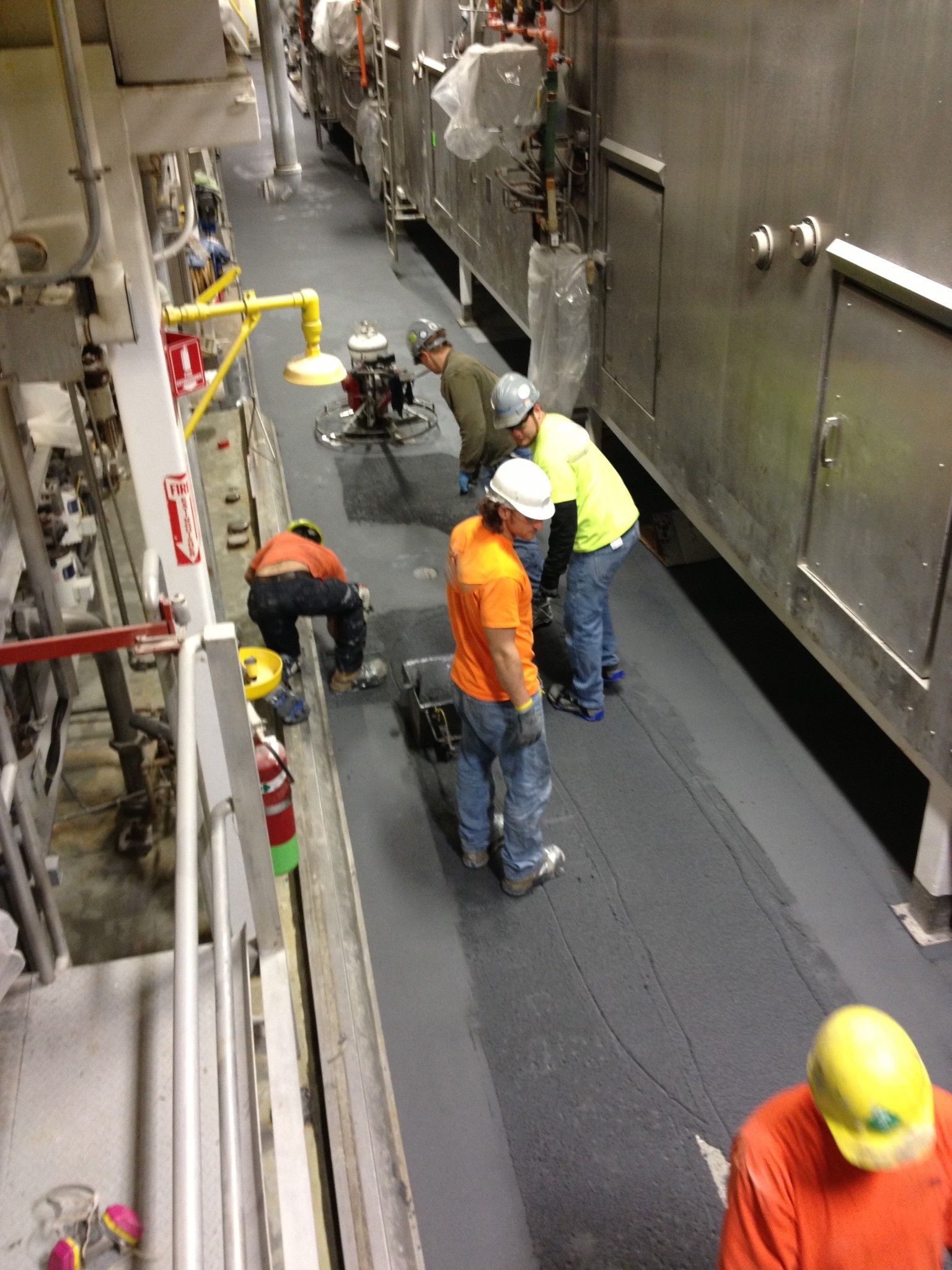 A group of men are working on a floor in a factory.