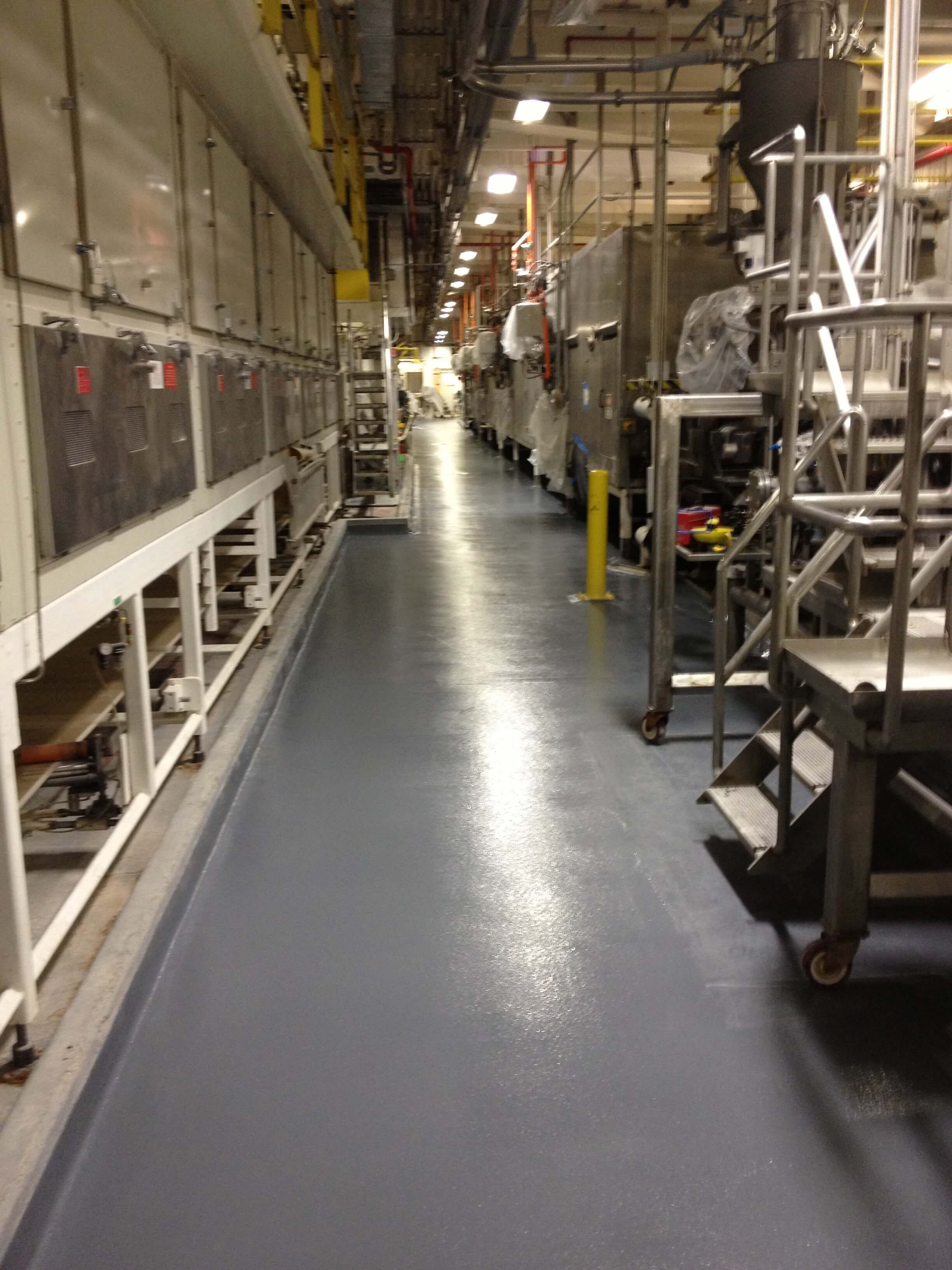 A long hallway in a factory with lots of machinery