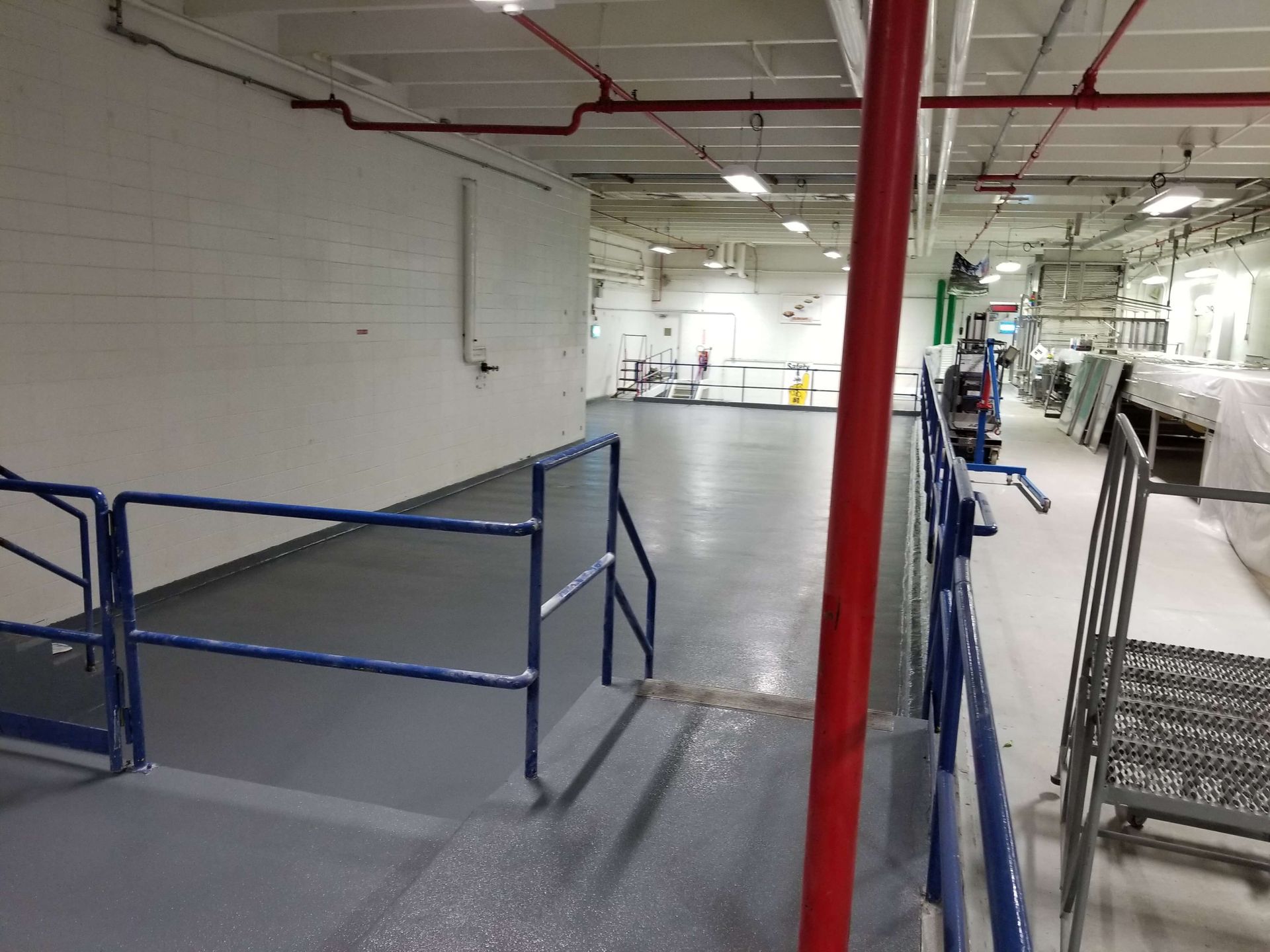 A warehouse with a blue railing and a red pole