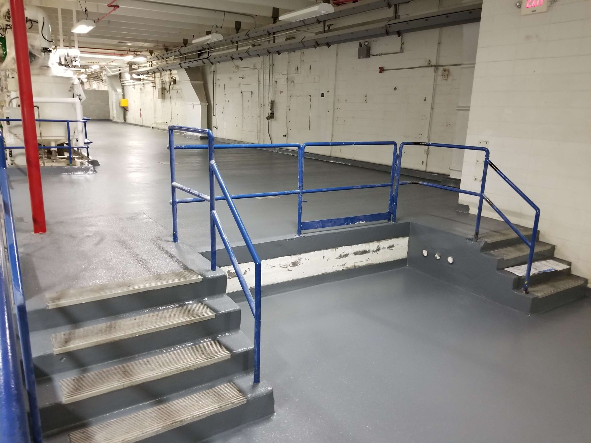 A room with stairs and a blue railing in it.