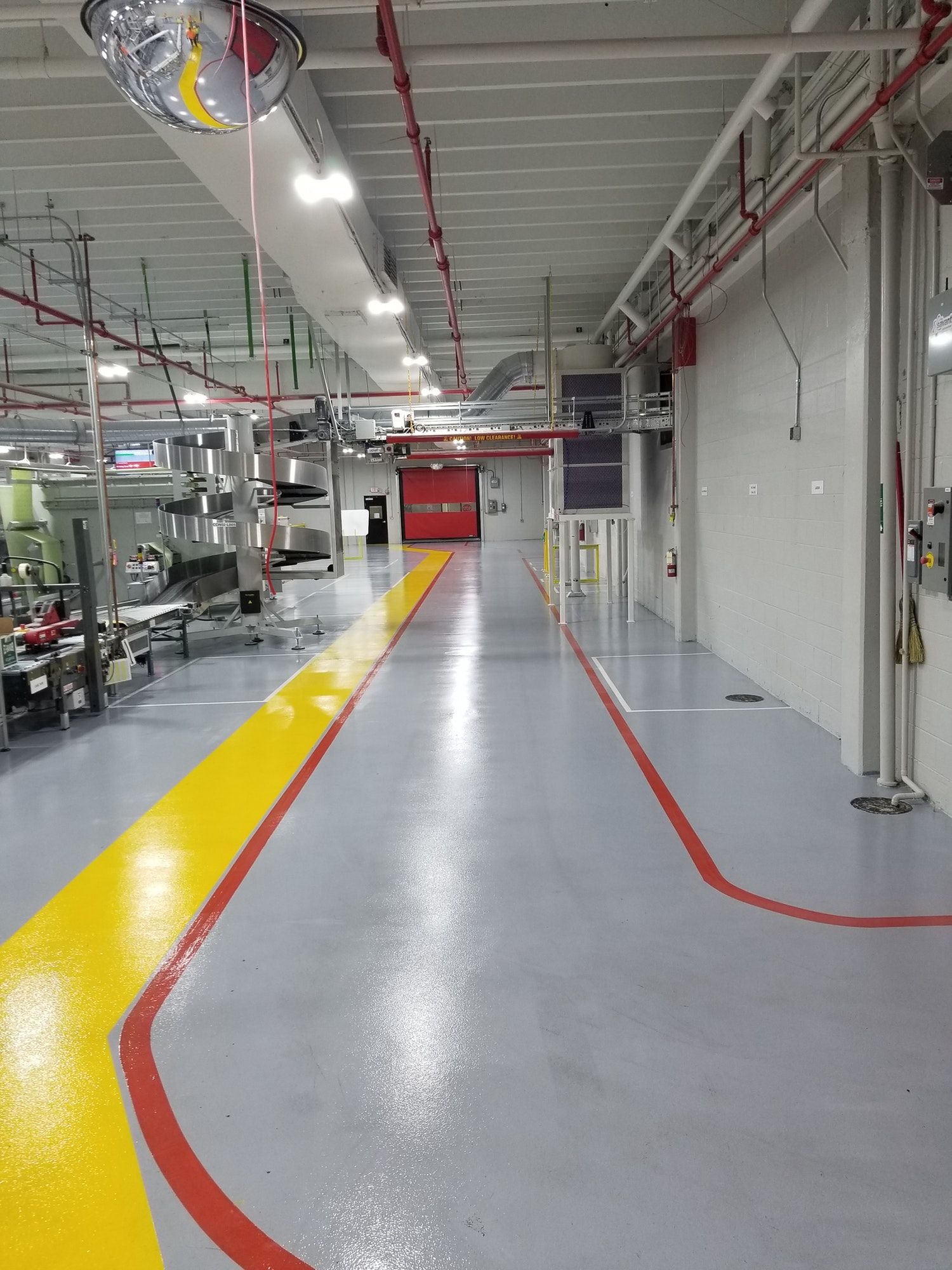 A long hallway in a factory with a yellow line on the floor