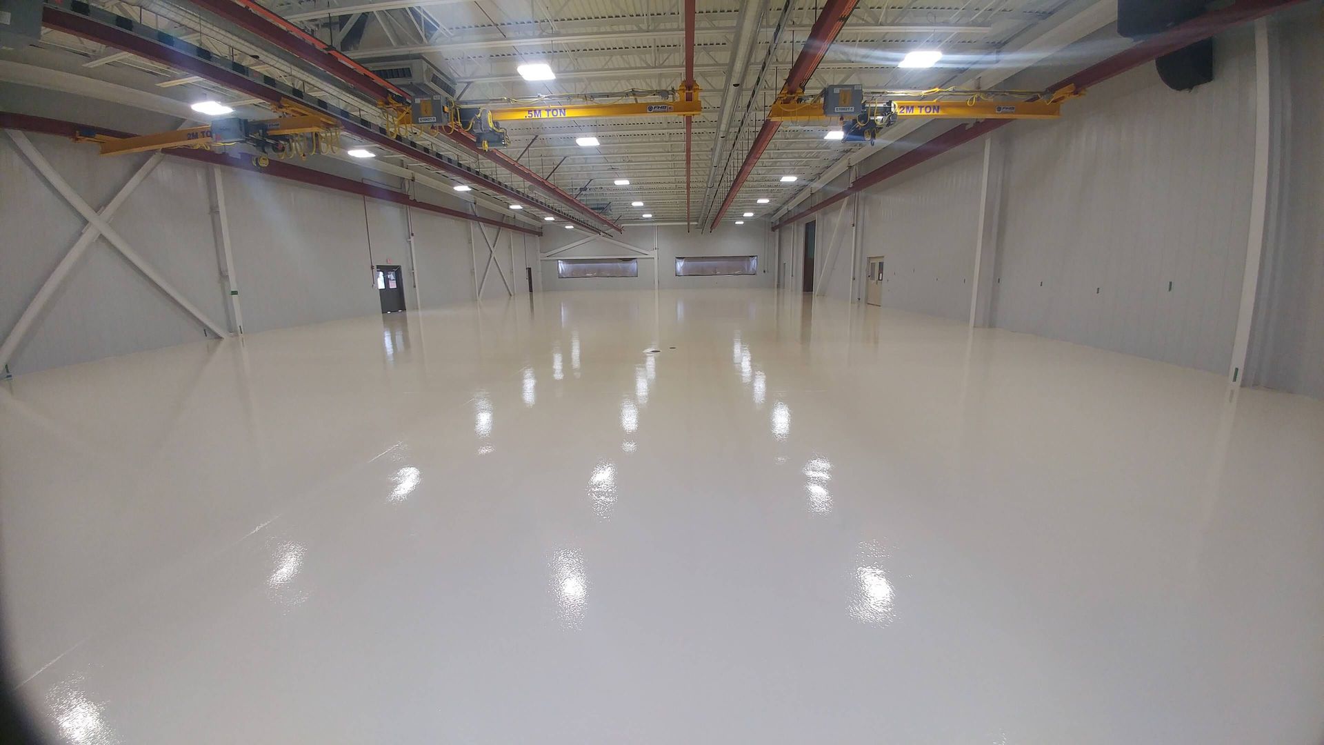 A large empty warehouse with a lot of lights on the floor.
