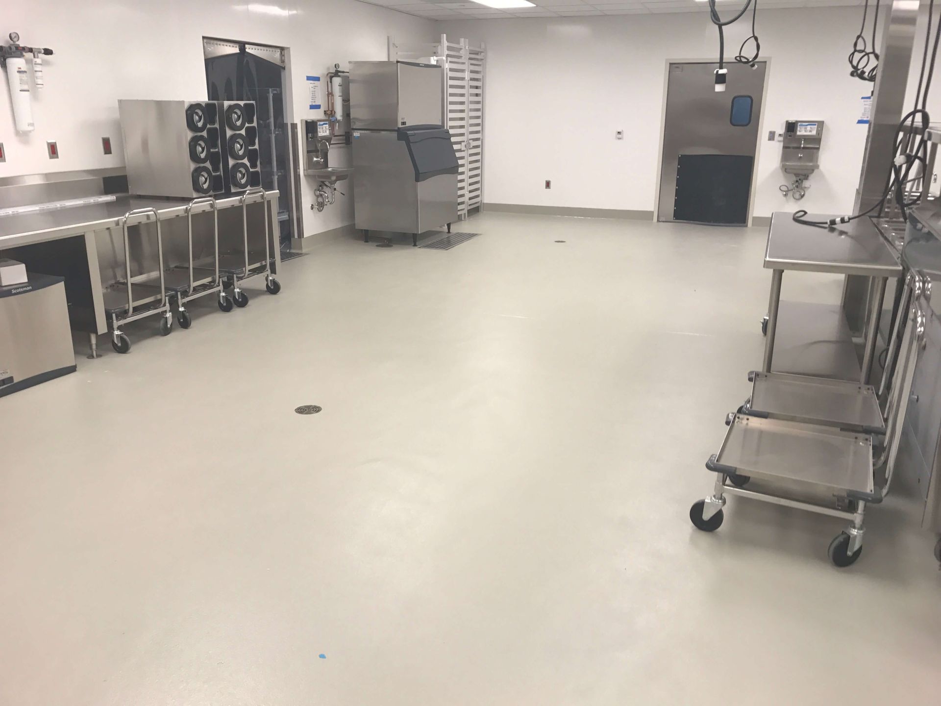 A large kitchen with stainless steel appliances and a white floor.