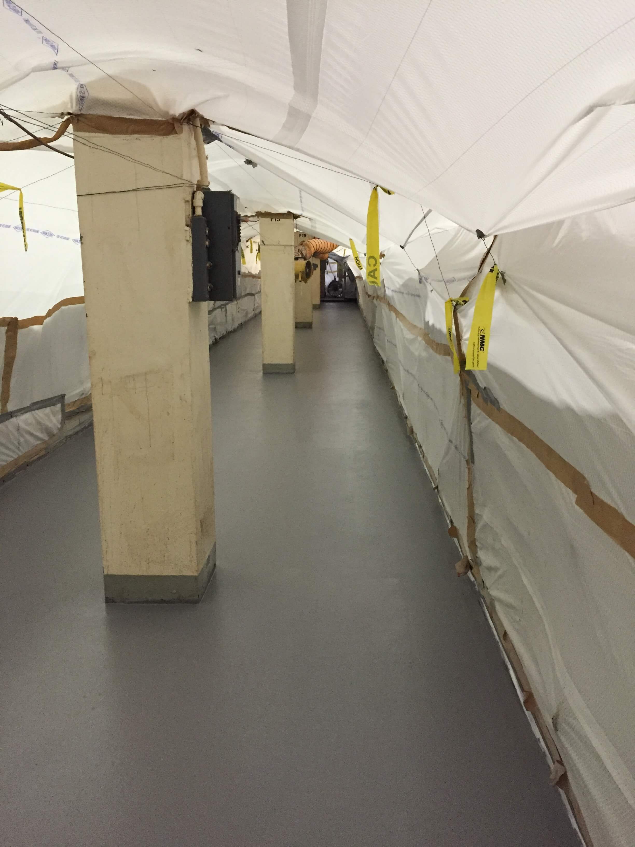 A long hallway with a white tarp over it