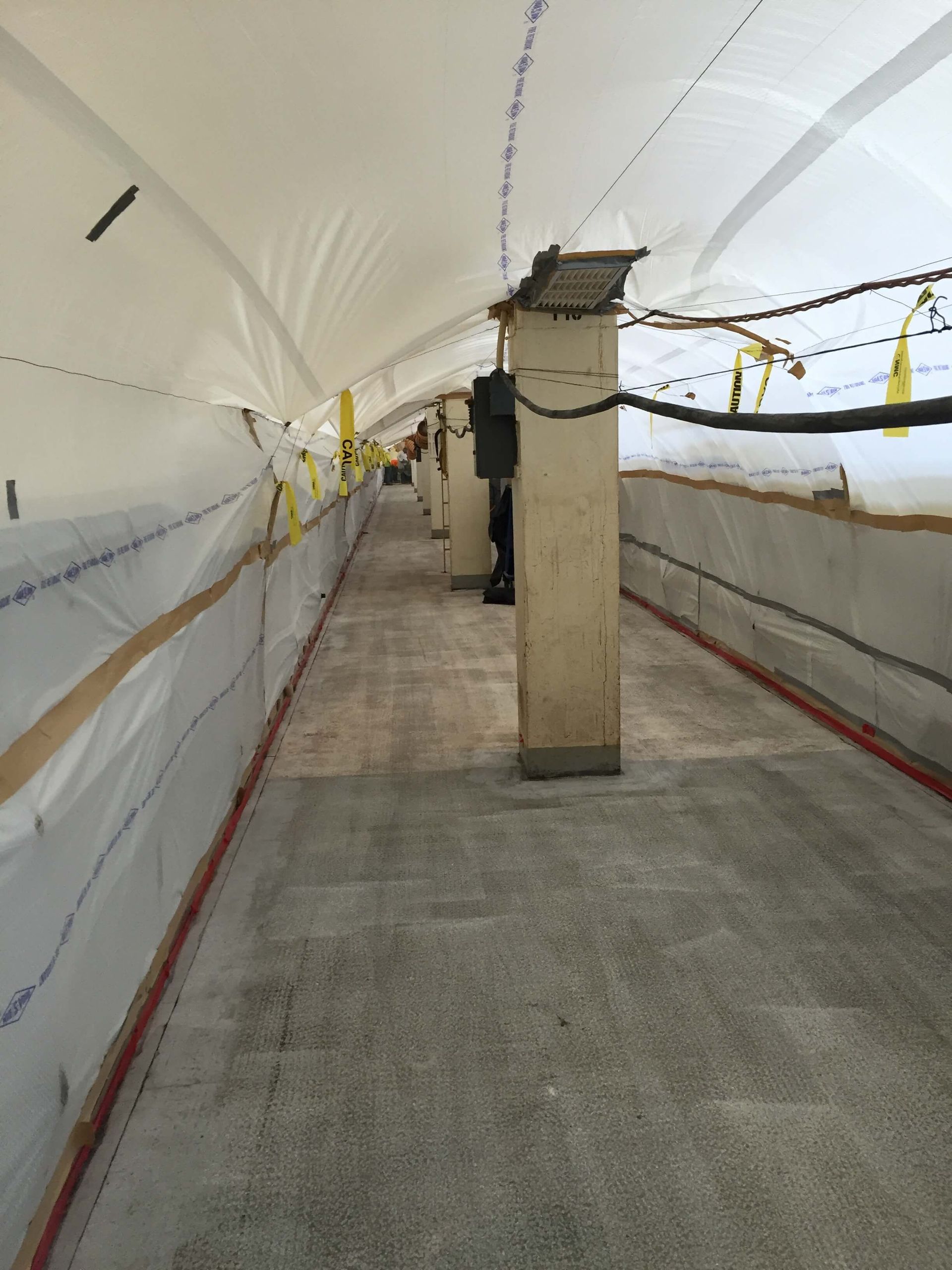 A long hallway with a white tarp on the ceiling