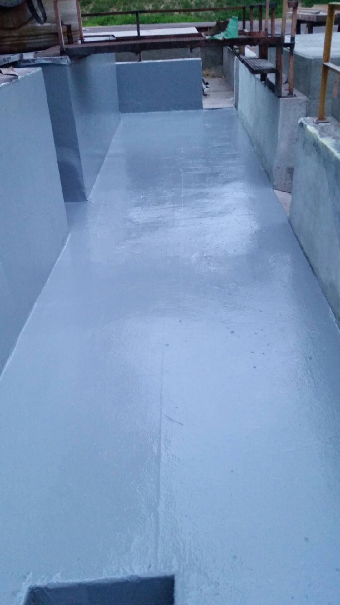 Grey-painted concrete surface, possibly a channel or tank, viewed from above.