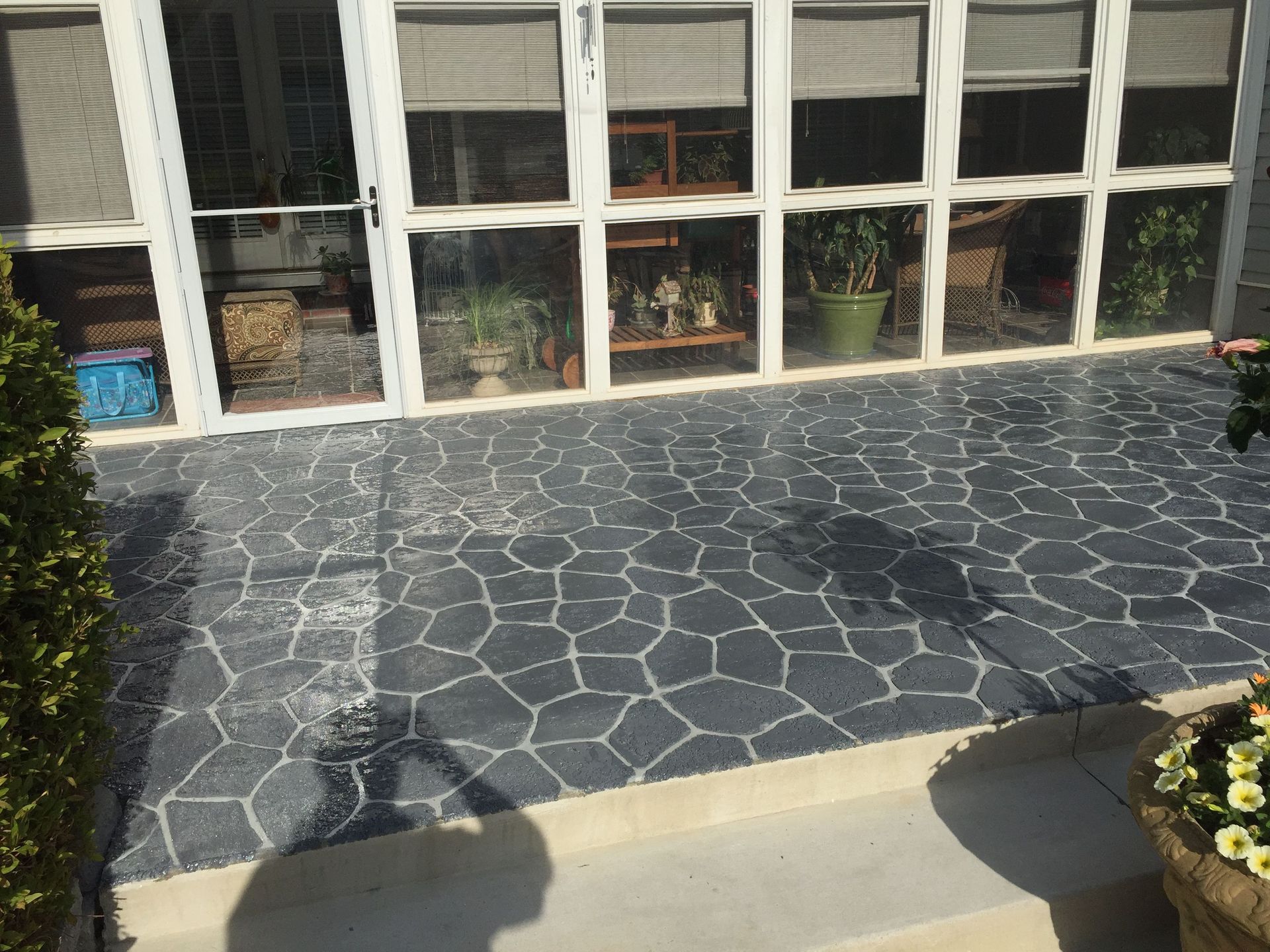 A patio with black and white decroative concrete door.