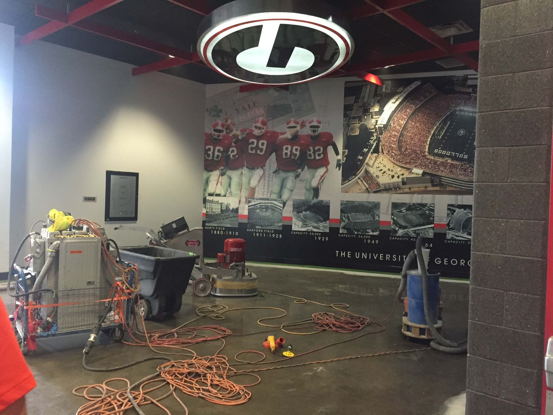 Construction site with concrete floor, power tools, and University of Georgia Bulldogs decor.