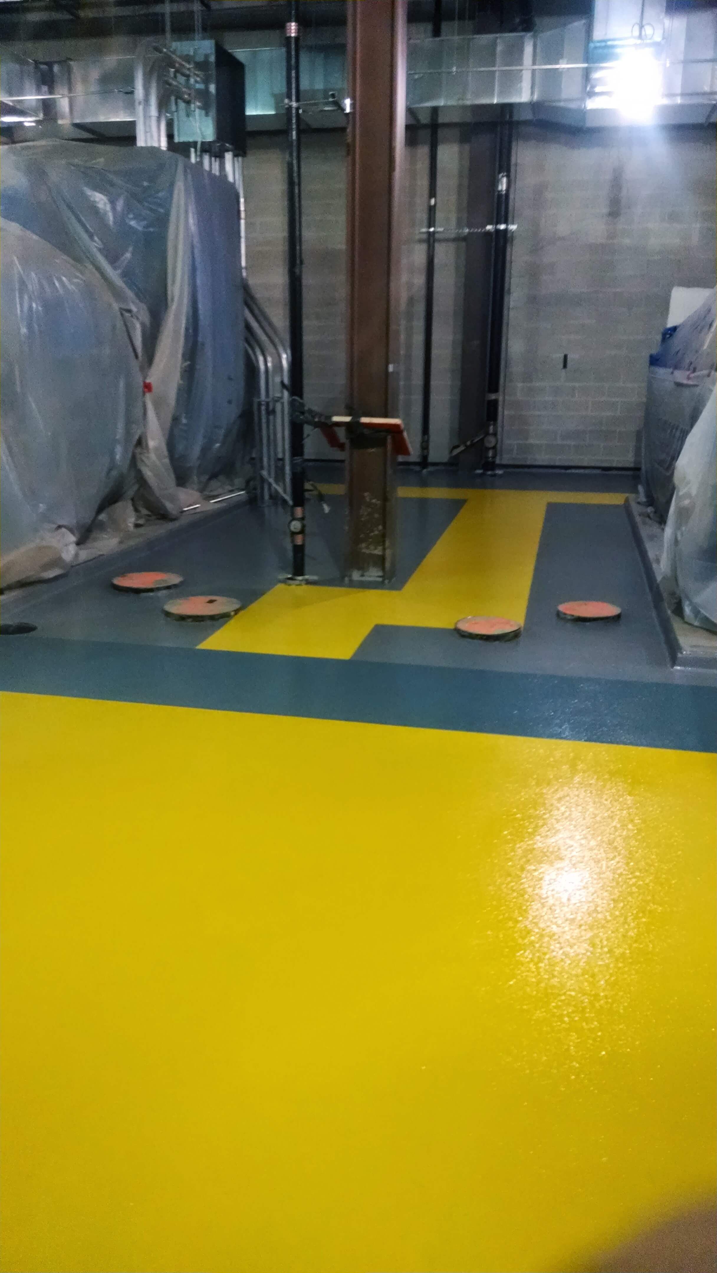 A yellow and blue floor in a building with a staircase.