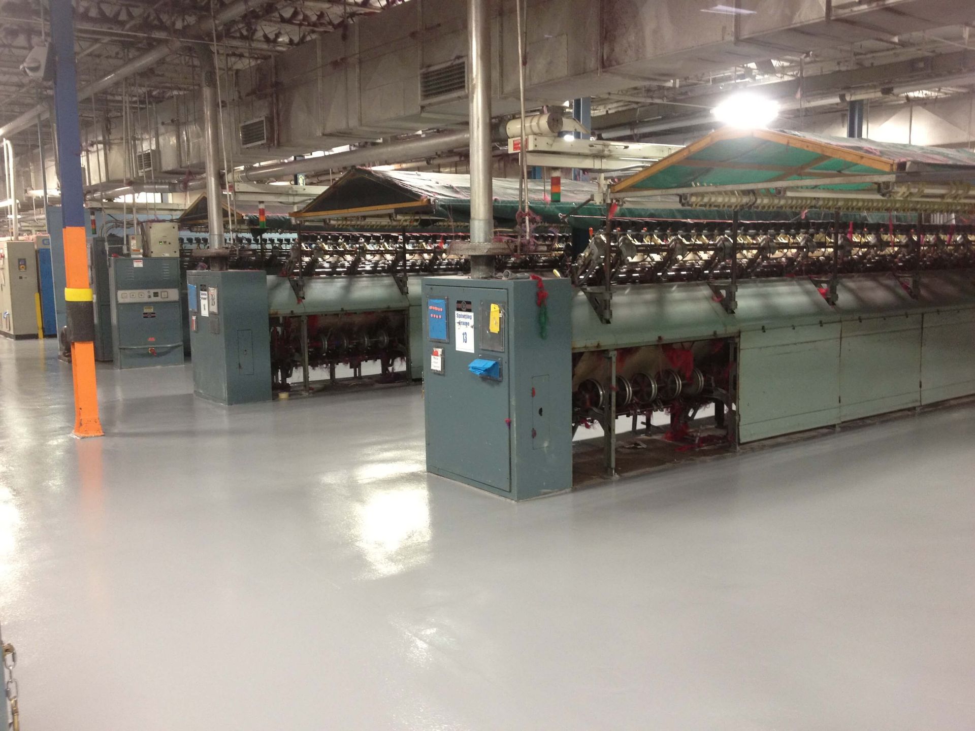 A factory with a lot of machinery and a gray floor.