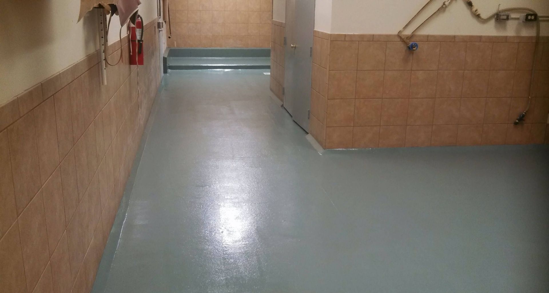 A long hallway with a fire extinguisher on the wall.