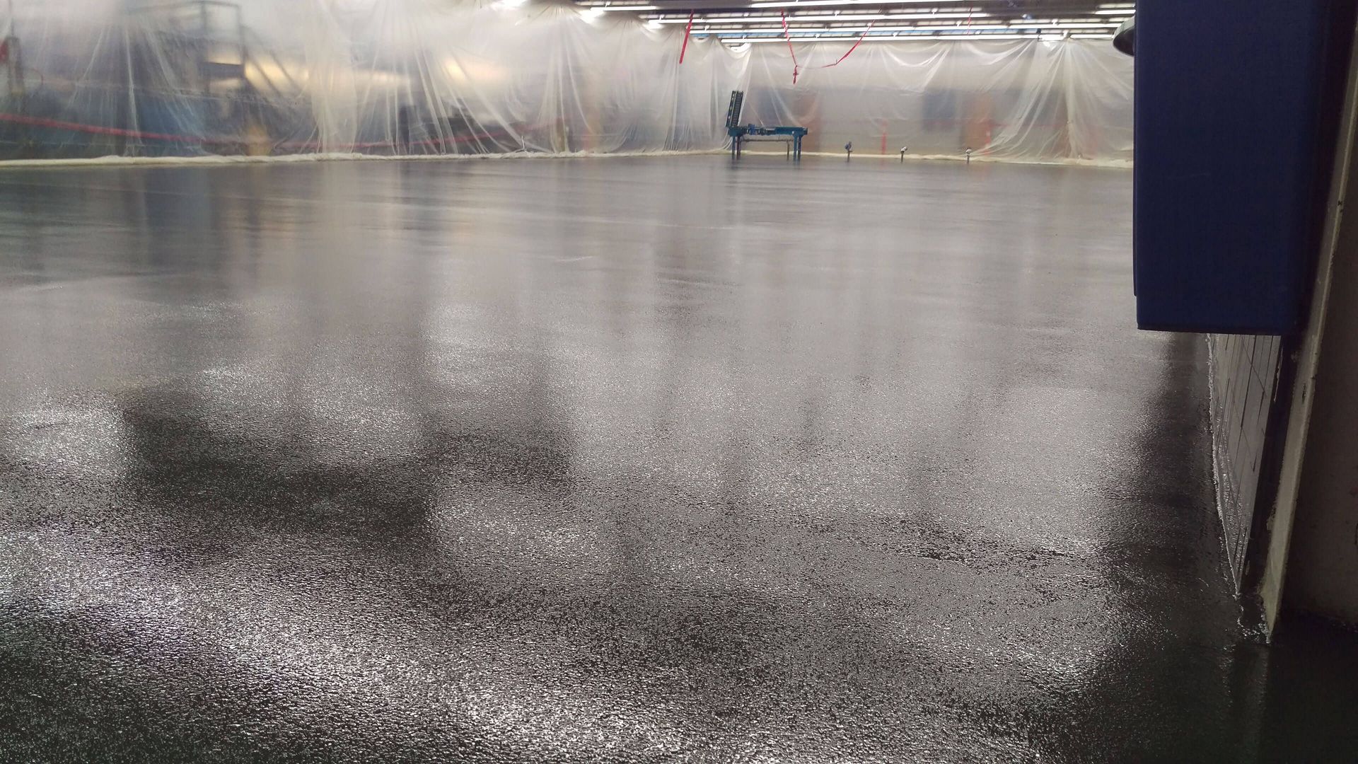 A person is standing on a bench in the rain on a wet floor.