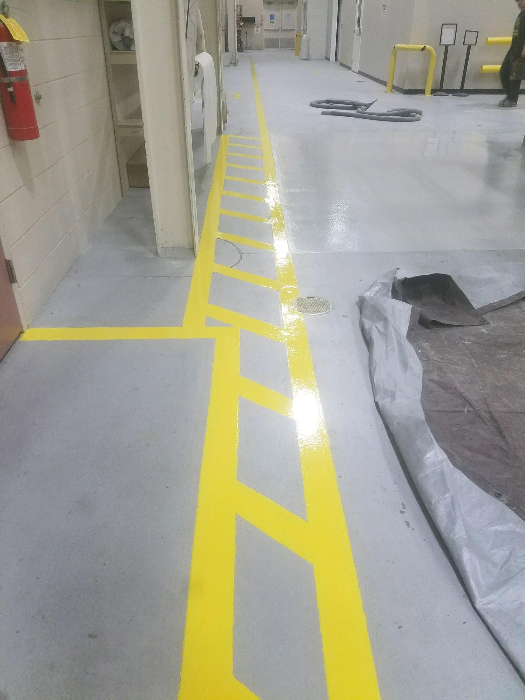 A hallway with yellow markings on the floor.