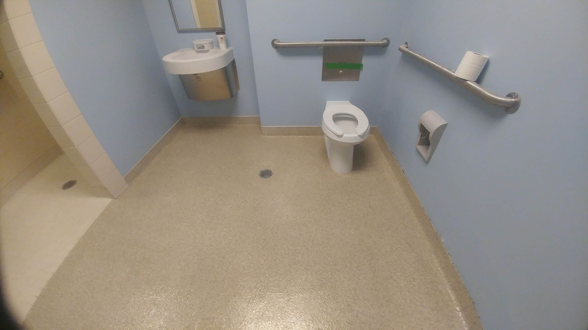 A bathroom with a toilet , sink and shower.