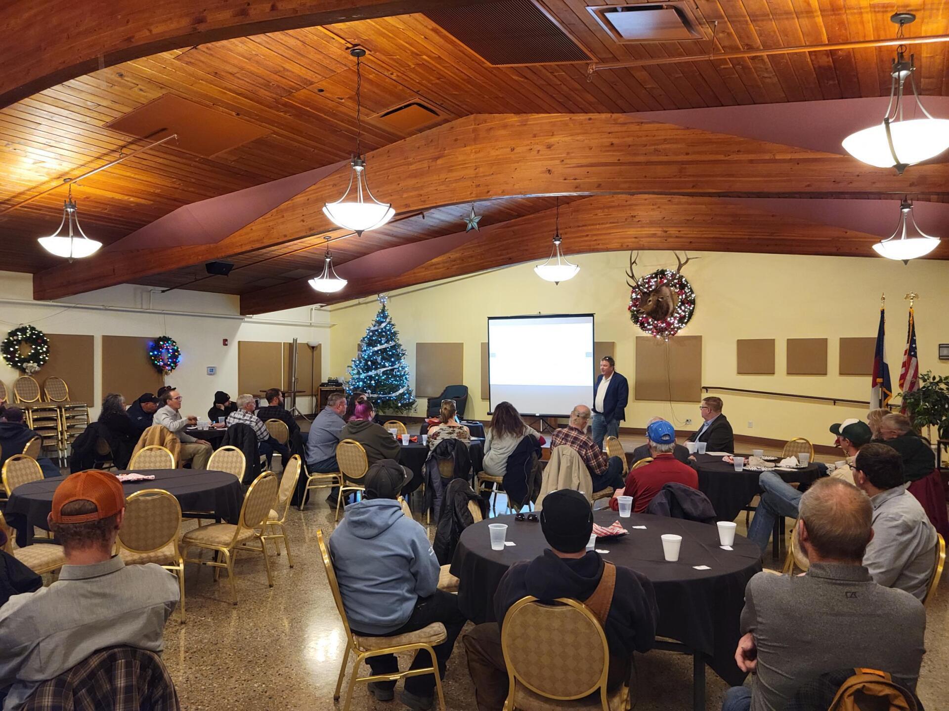 A group of people are sitting at tables in a large room
