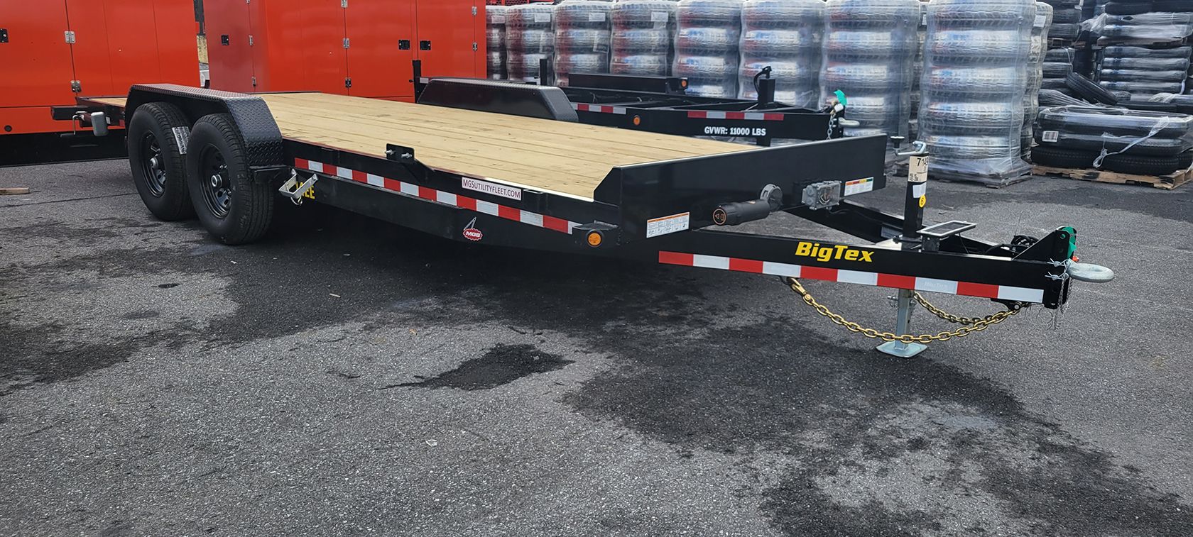 A flatbed trailer is parked on the side of the road.