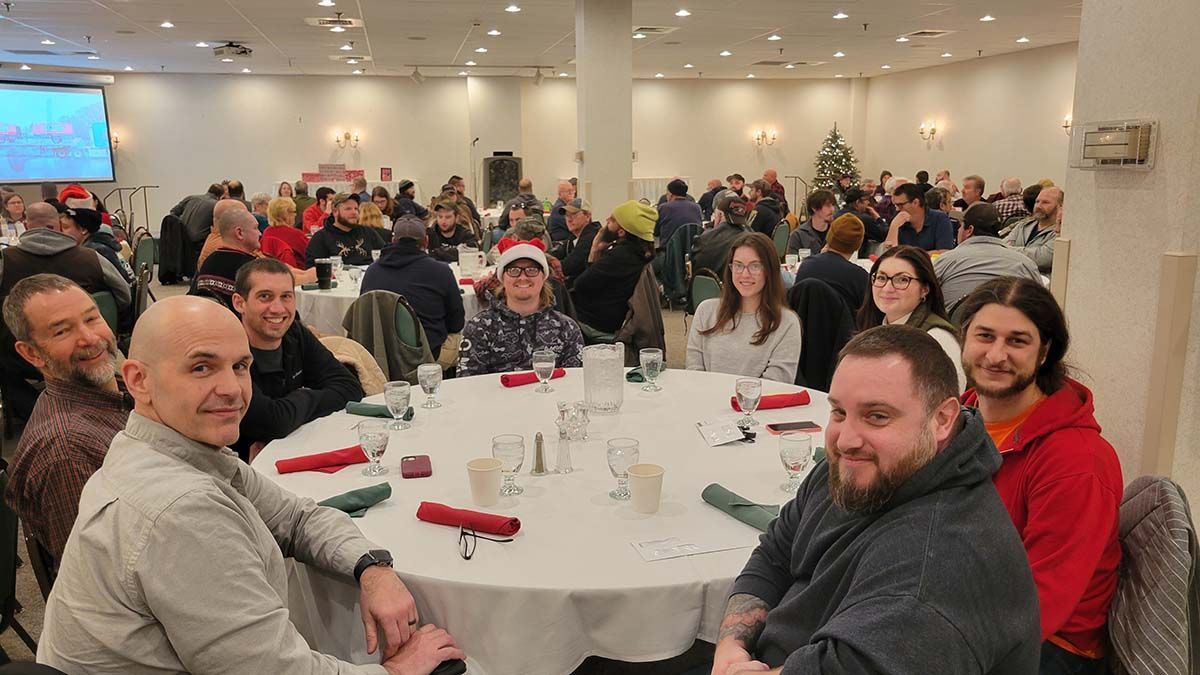 A group of people are sitting at tables in a large room.